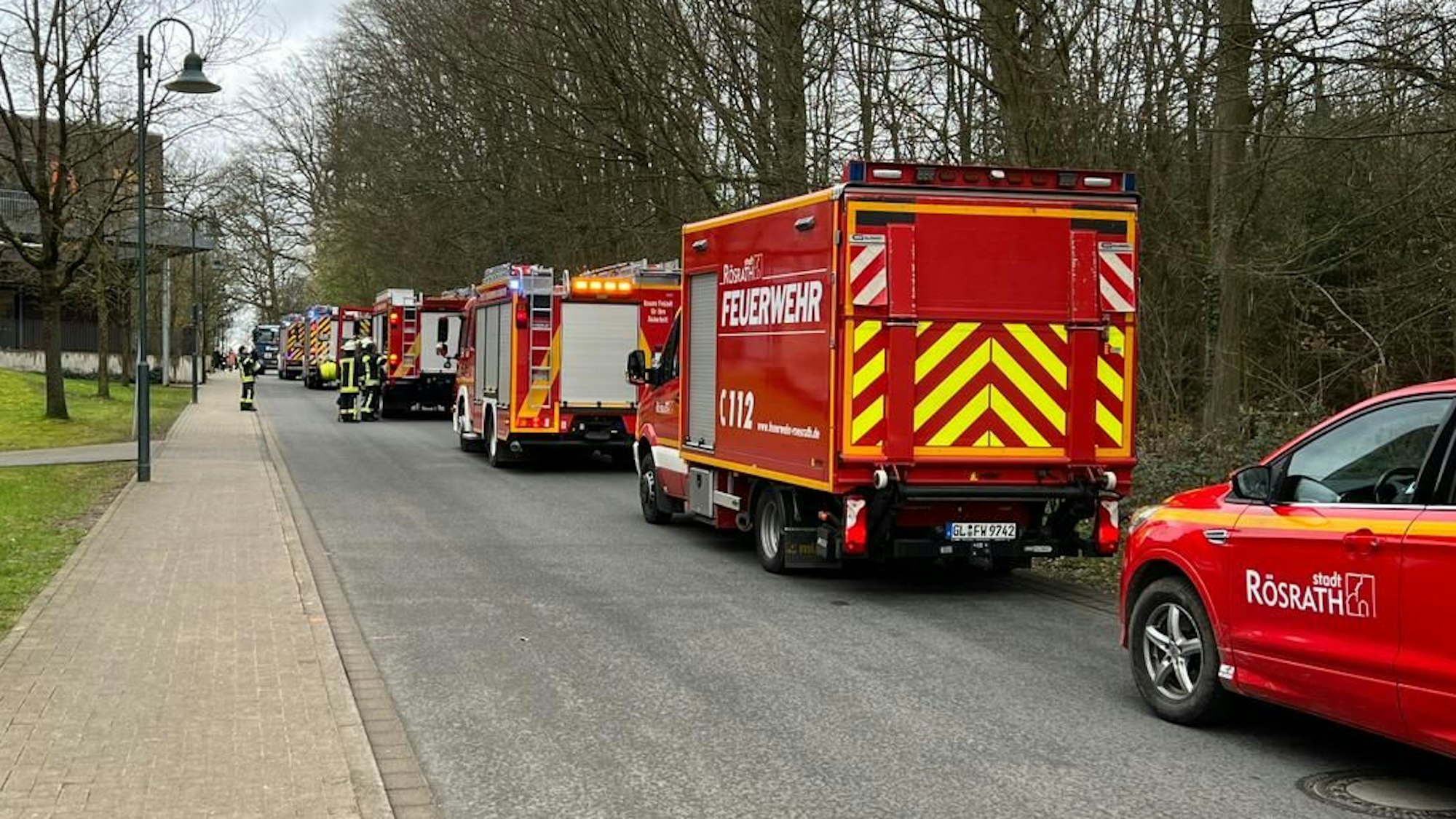 Feuerwehrfahrzeuge stehen an der Straße zur LVR-Schule am Königsforst in Rösrath.