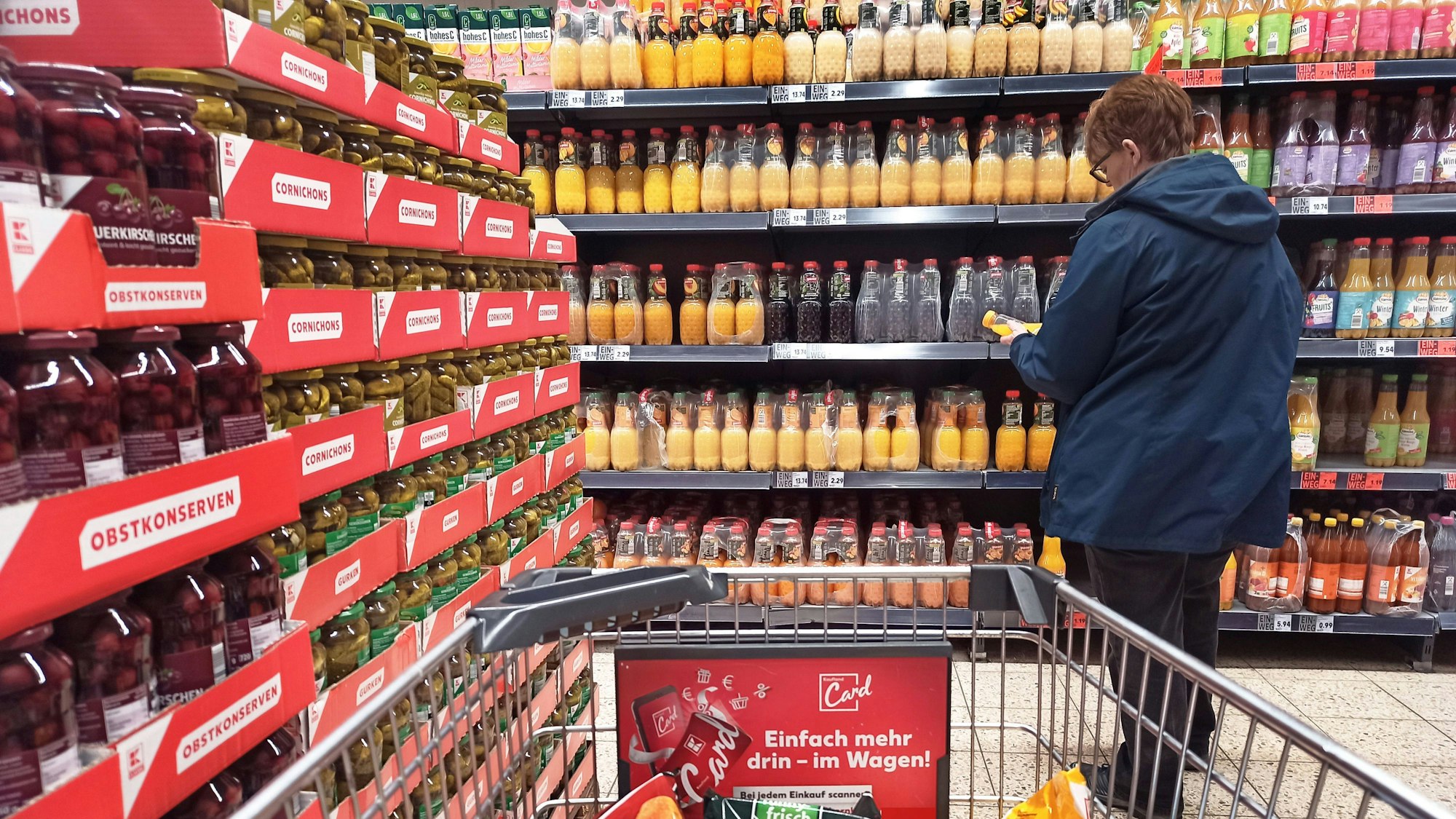 Eine Frau sucht Getränke in einem Supermarkt-Regal. (Symbolbild)