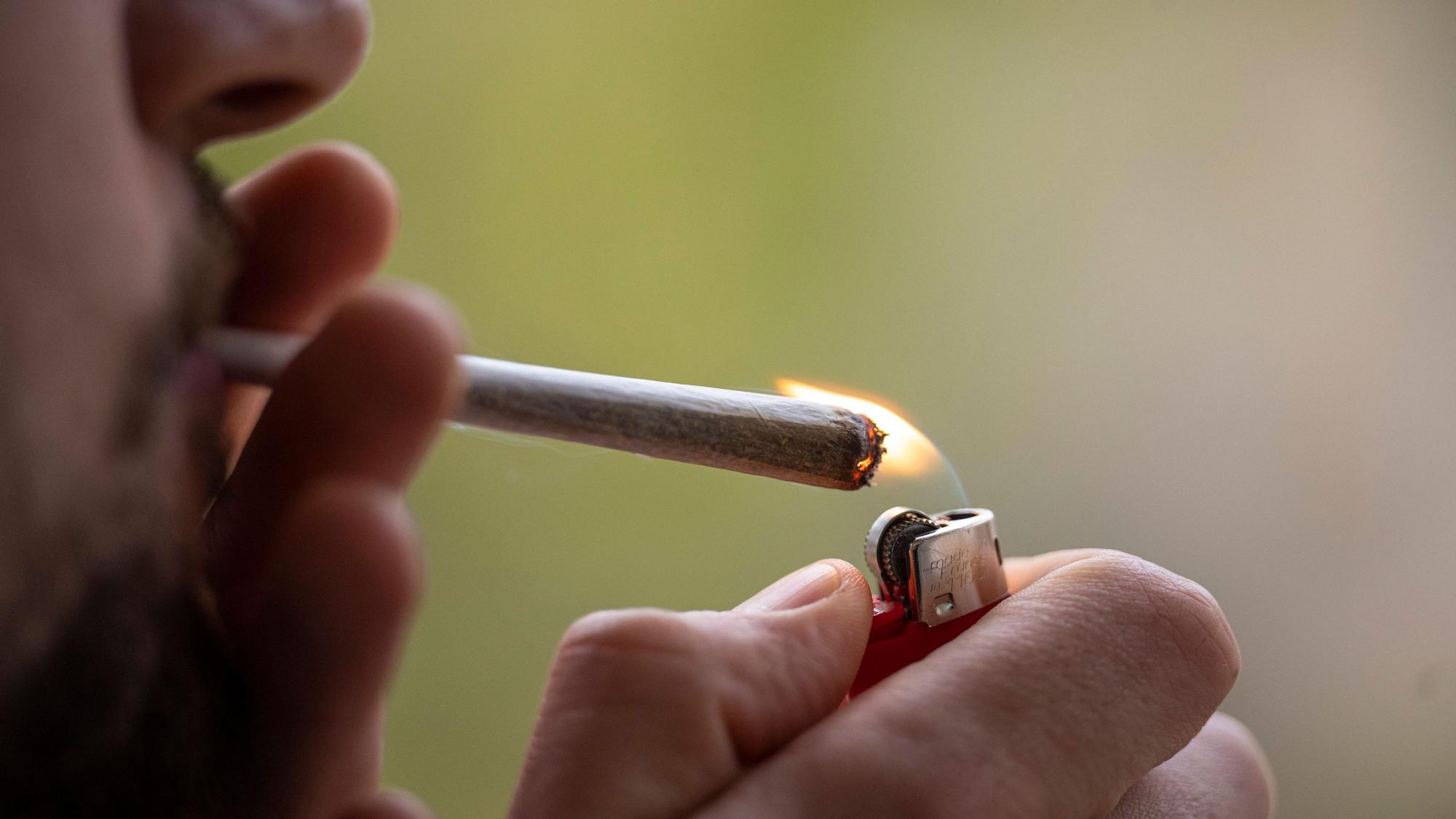 Ein Mann zündet sich einen Joint an.