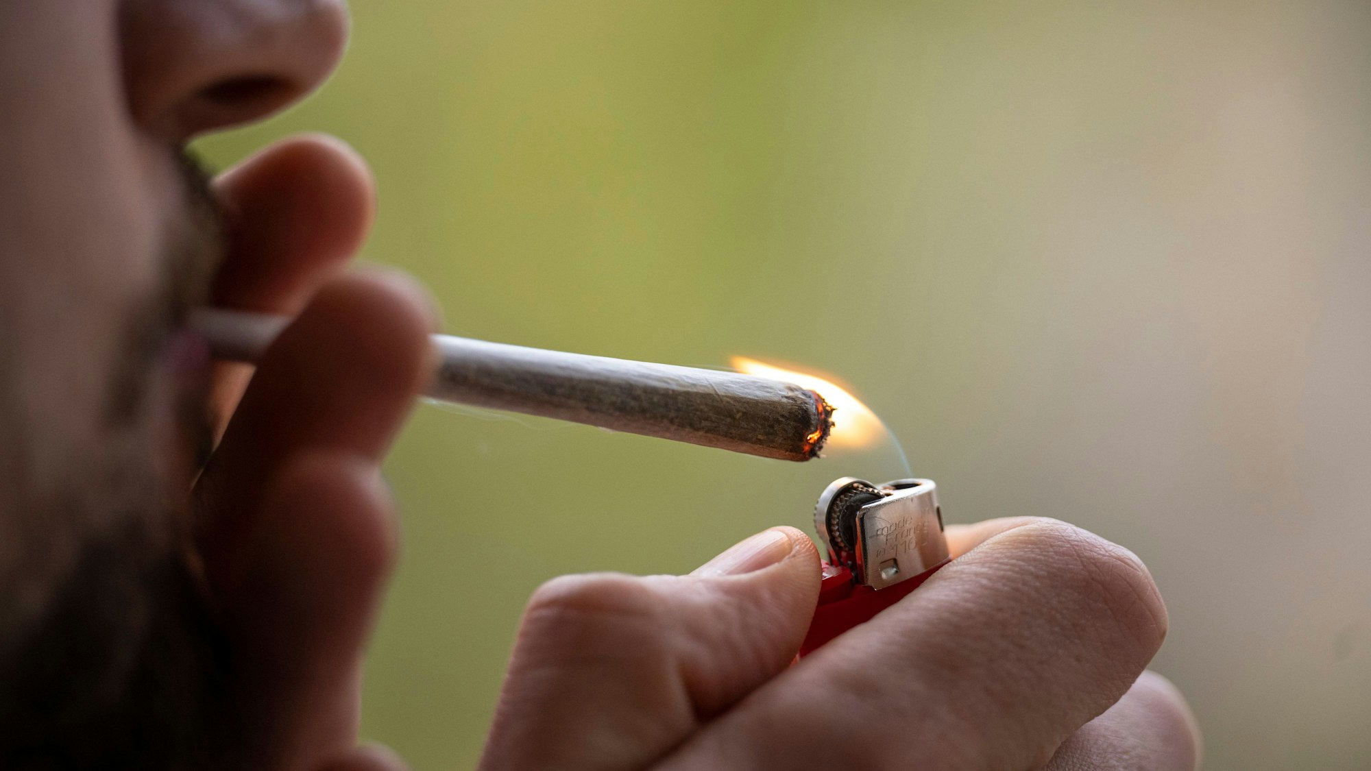 Ein Mann zündet sich einen Joint an.