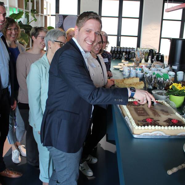 Markus Ramers schneidet eine Torte an, um ihn herum steht das Team der Nordeifel-Tourismus GmbH.