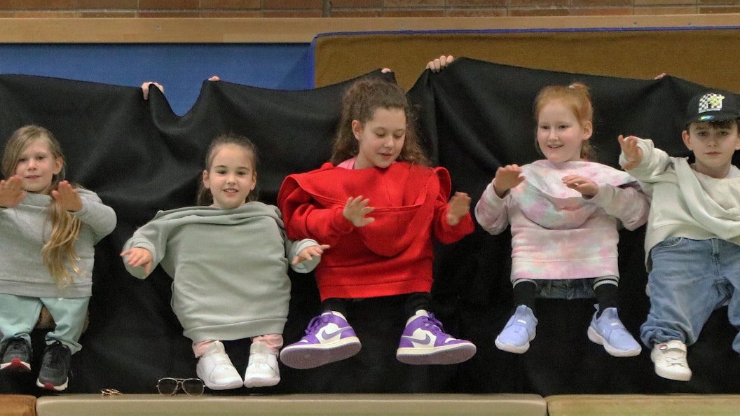 Auf dem Bild sind Kinder zu sehen, die einen Zwergentanz aufführen.