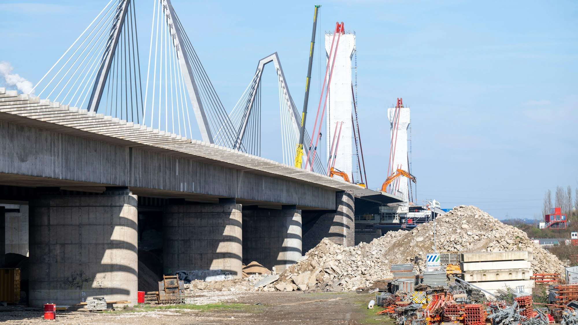 Blick auf die Leverkusener Brücke, ein großer Schuttberg türmt sich neben dem stillgelegten alten Brückenteil.