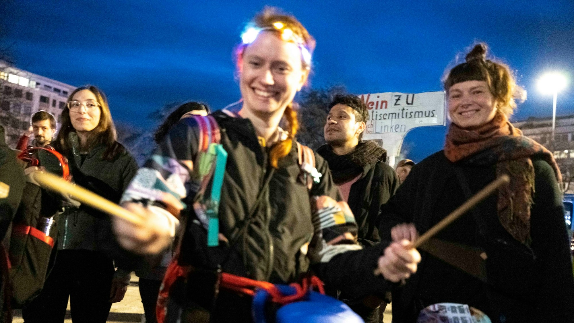 Eine Demonstrantin von „Donnern gegen Rechts“ trommelt in der Luft.