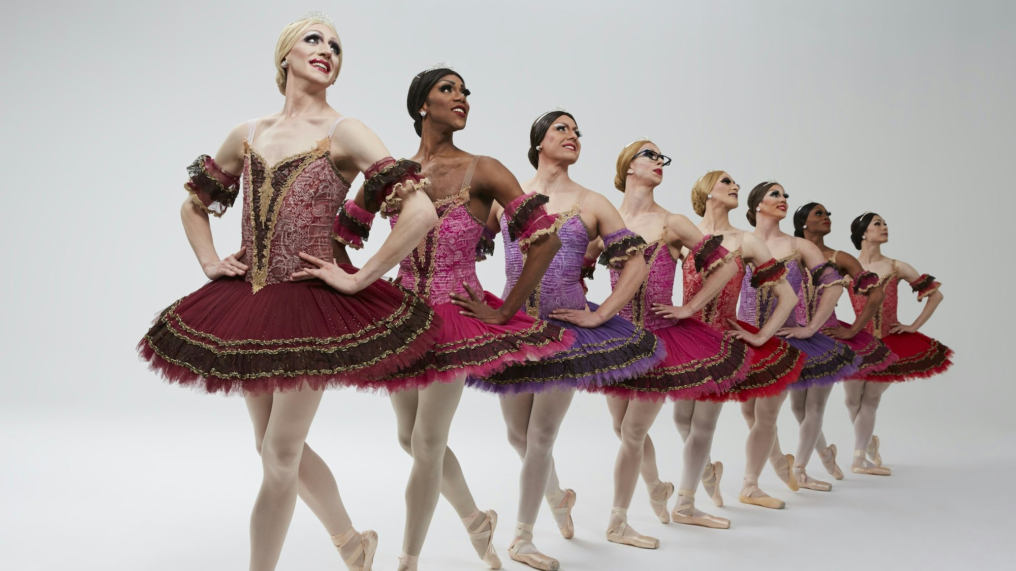 Auf dem Bild sind acht Männer in Balletkleidern zusehen.