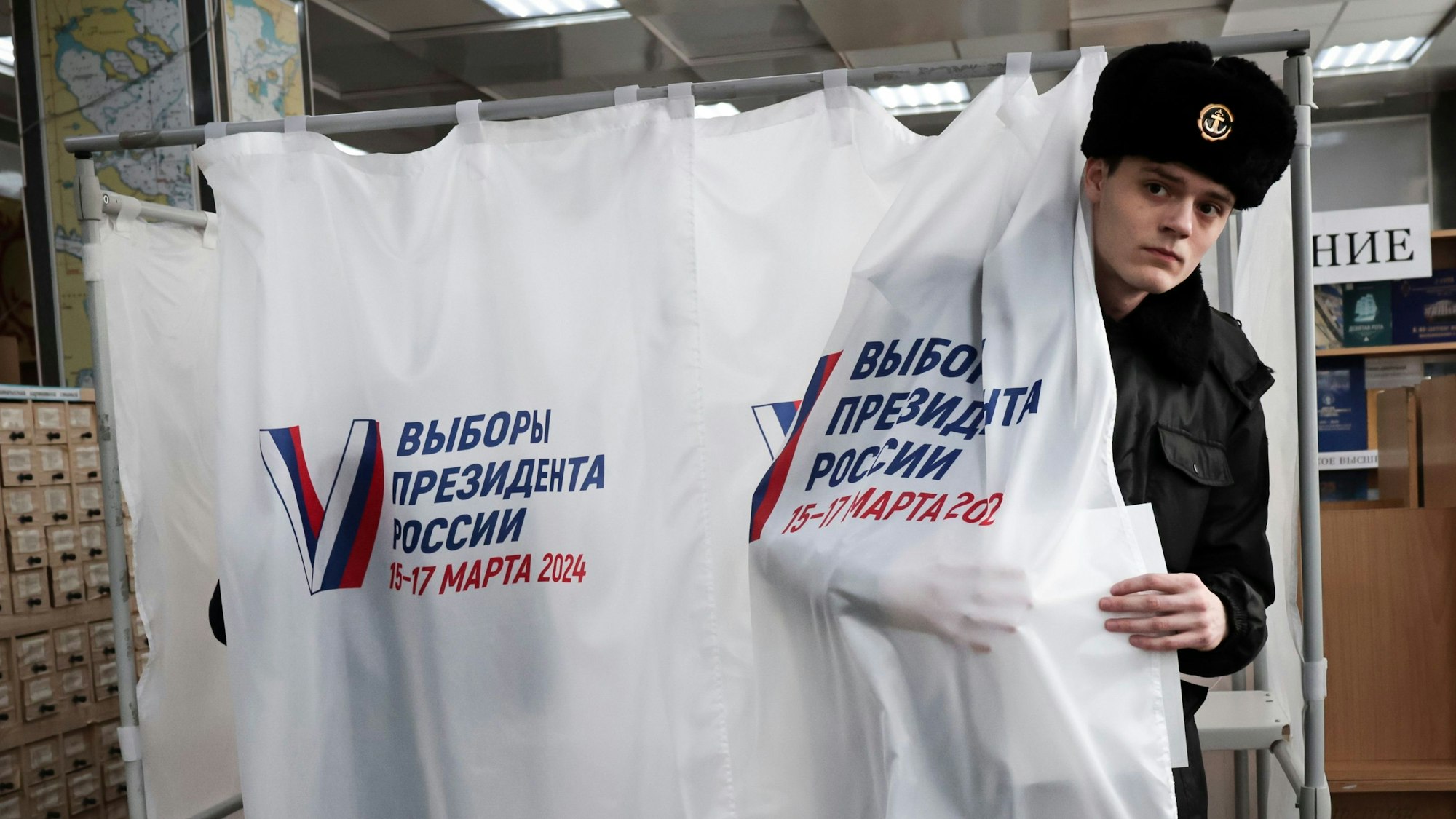 Ein Student der Maritimen Staatlichen Universität verlässt nach seiner Stimmabgabe bei Putins Scheinwahl in Russland eine Kabine in Wladiwostok.