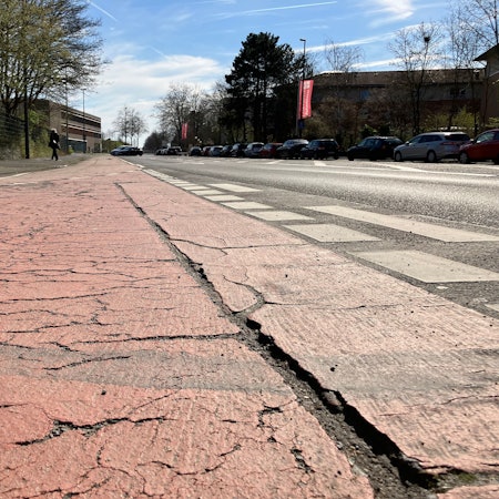 Der Radweg Sürther Straße vor der Einbiegung Eygelshofener Straße in Rodenkirchen, weist Rillen und Risse auf.