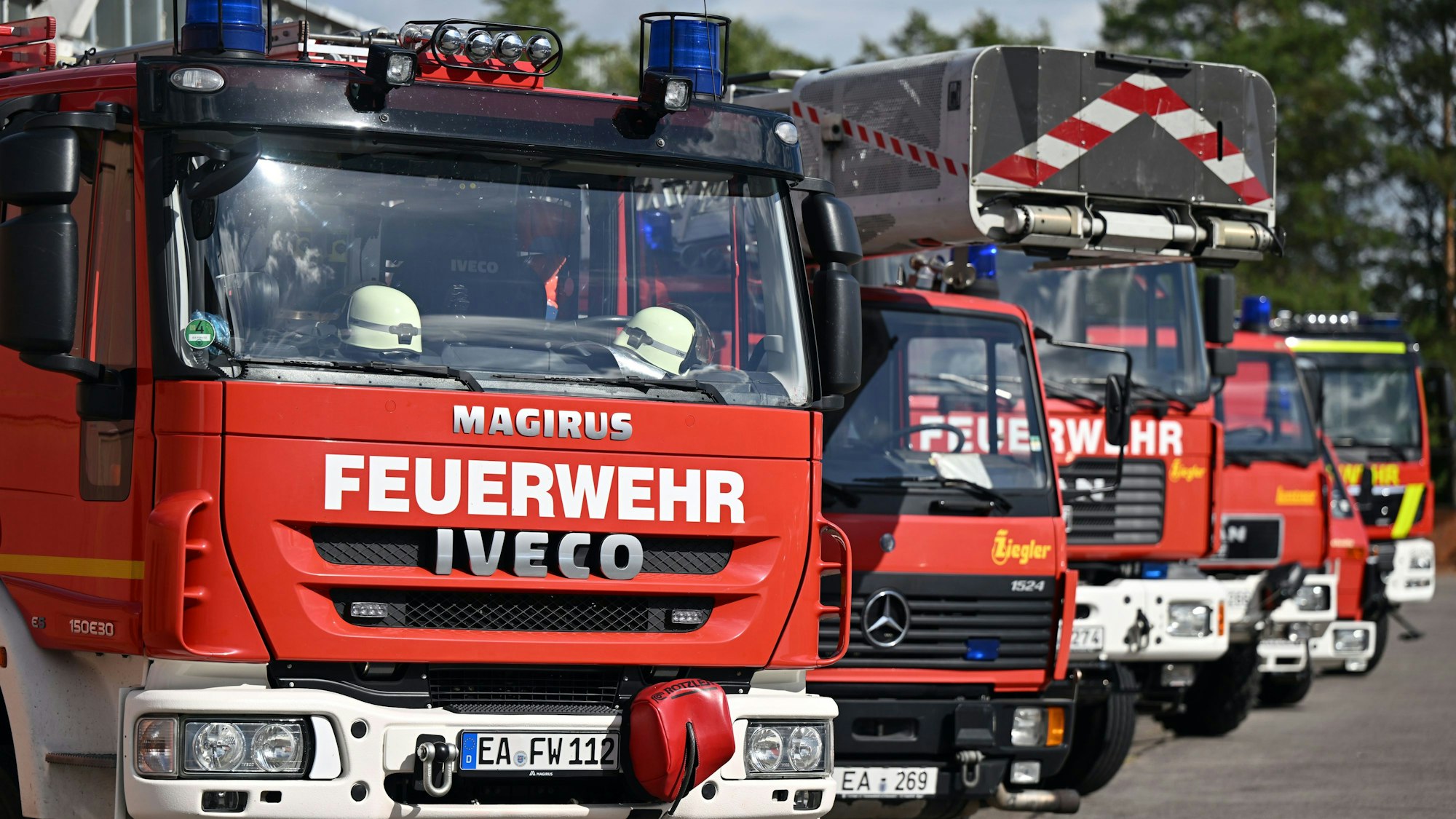 Einsatzfahrzeuge stehen in der Feuerwache nebeneinander.