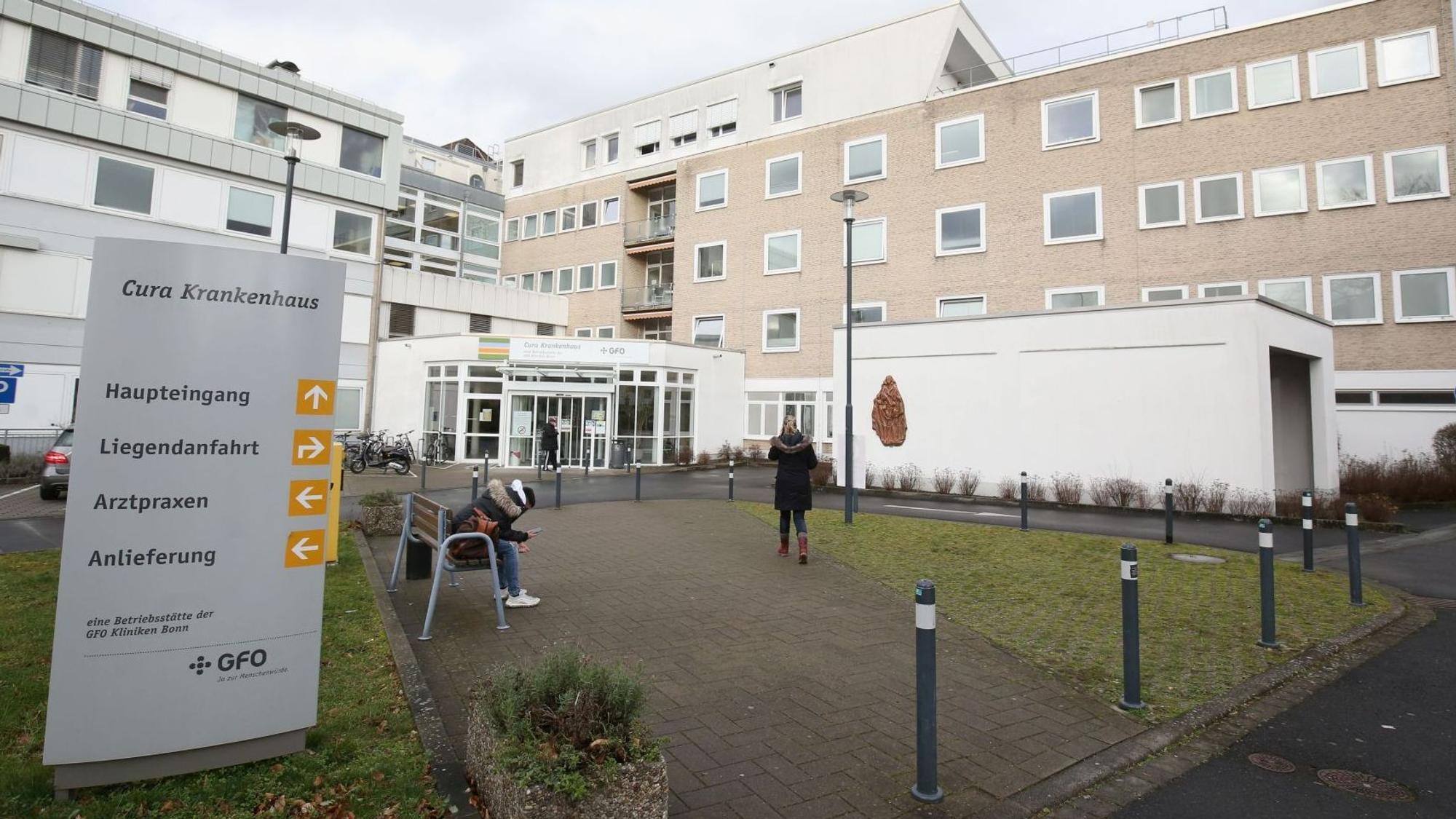 Der Eingangsbereich des Bad Honnefer Cura-Krankenhauses. Auf einer Bank sitzt eine Person.