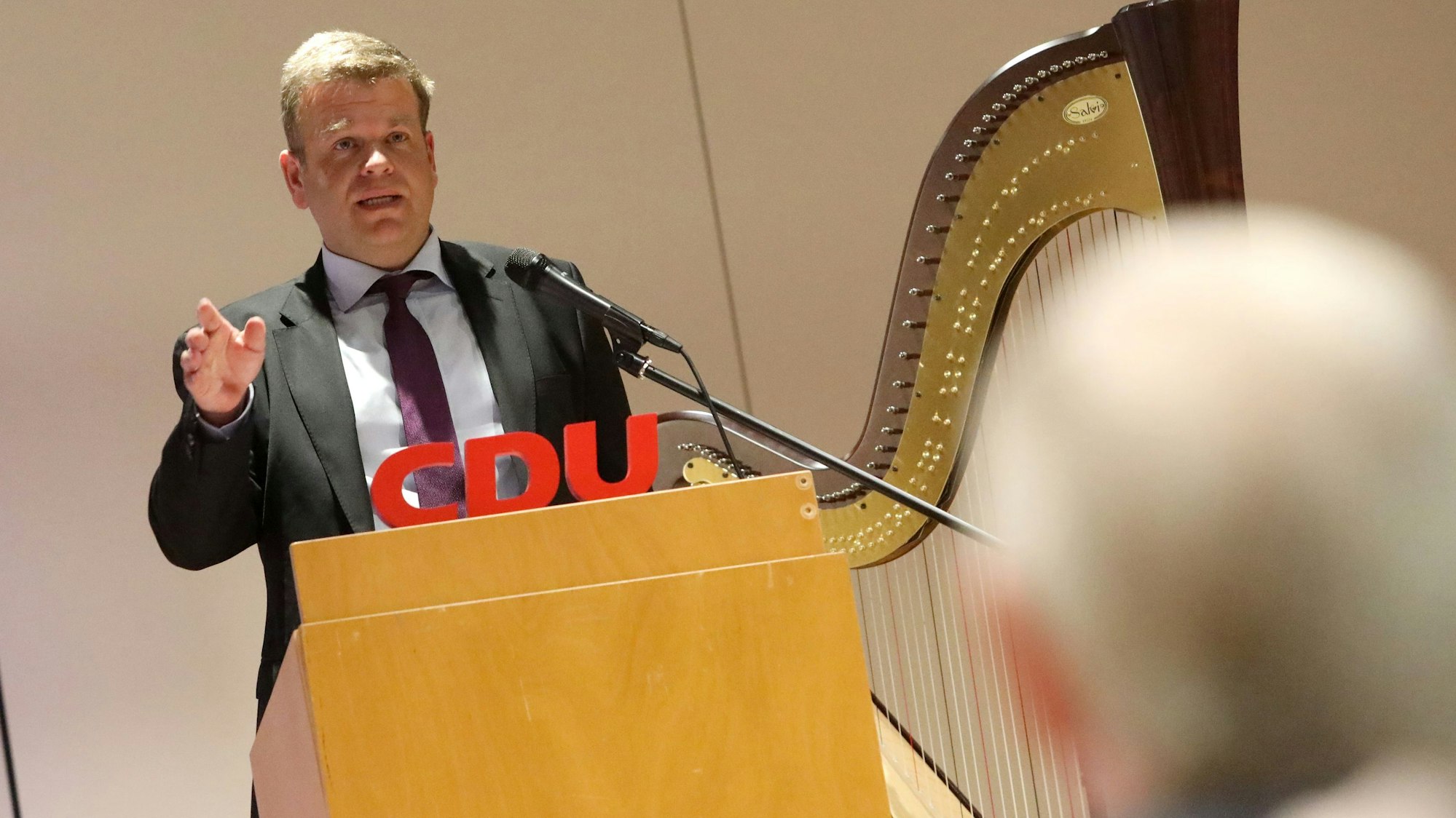 Ein Mann an einem Stehpult, an dem der Schriftzug CDU montiert ist.