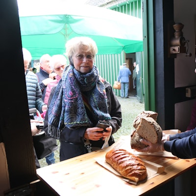 Ein Mann packt einer Frau Brot ein.