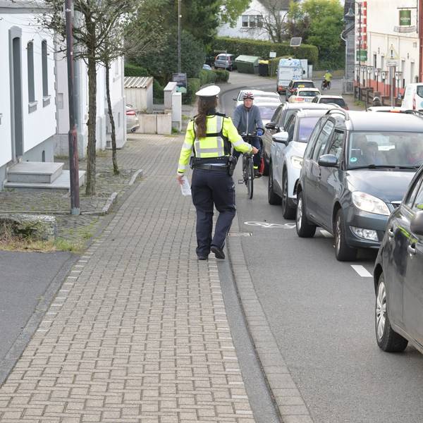 Bei der Aktion "Mehr Miteinander im Verkehr" beobachtet eine Polizistin den Rad-Schutzstreifen
auf der Bensberger Straße in Forsbach.