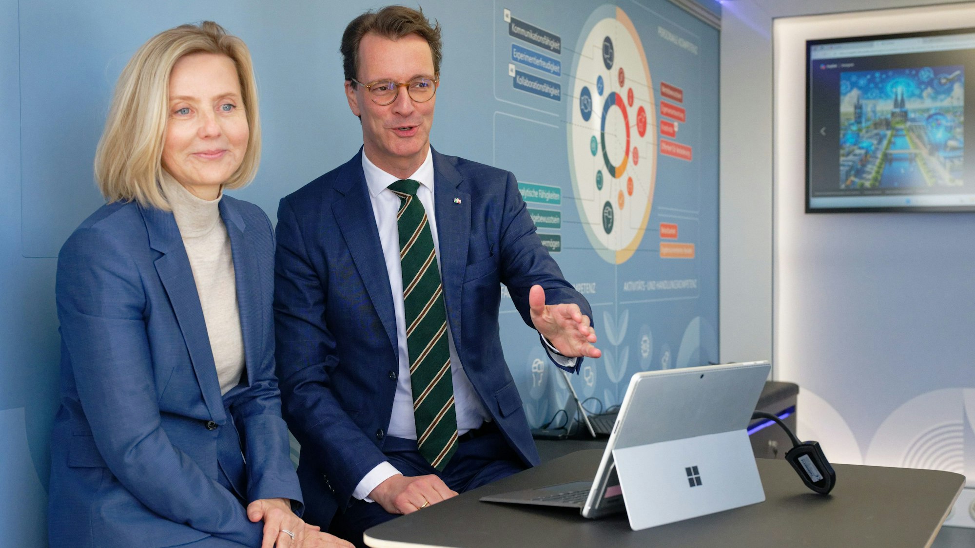 18.03.2024, Nordrhein-Westfalen, Elsdorf: Marianne Janik, Vorsitzende der Geschäftsführung von Microsoft Deutschland (l), und Hendrik Wüst, Ministerpräsident des Landes Nordrhein-Westfalen (CDU), beobachten vor einer Pressekonferenz zum Thema "Von der Kohle zur KI" auf einem Bildschirm die Arbeit einer KI-Applikation. Foto: Henning Kaiser/dpa +++ dpa-Bildfunk +++