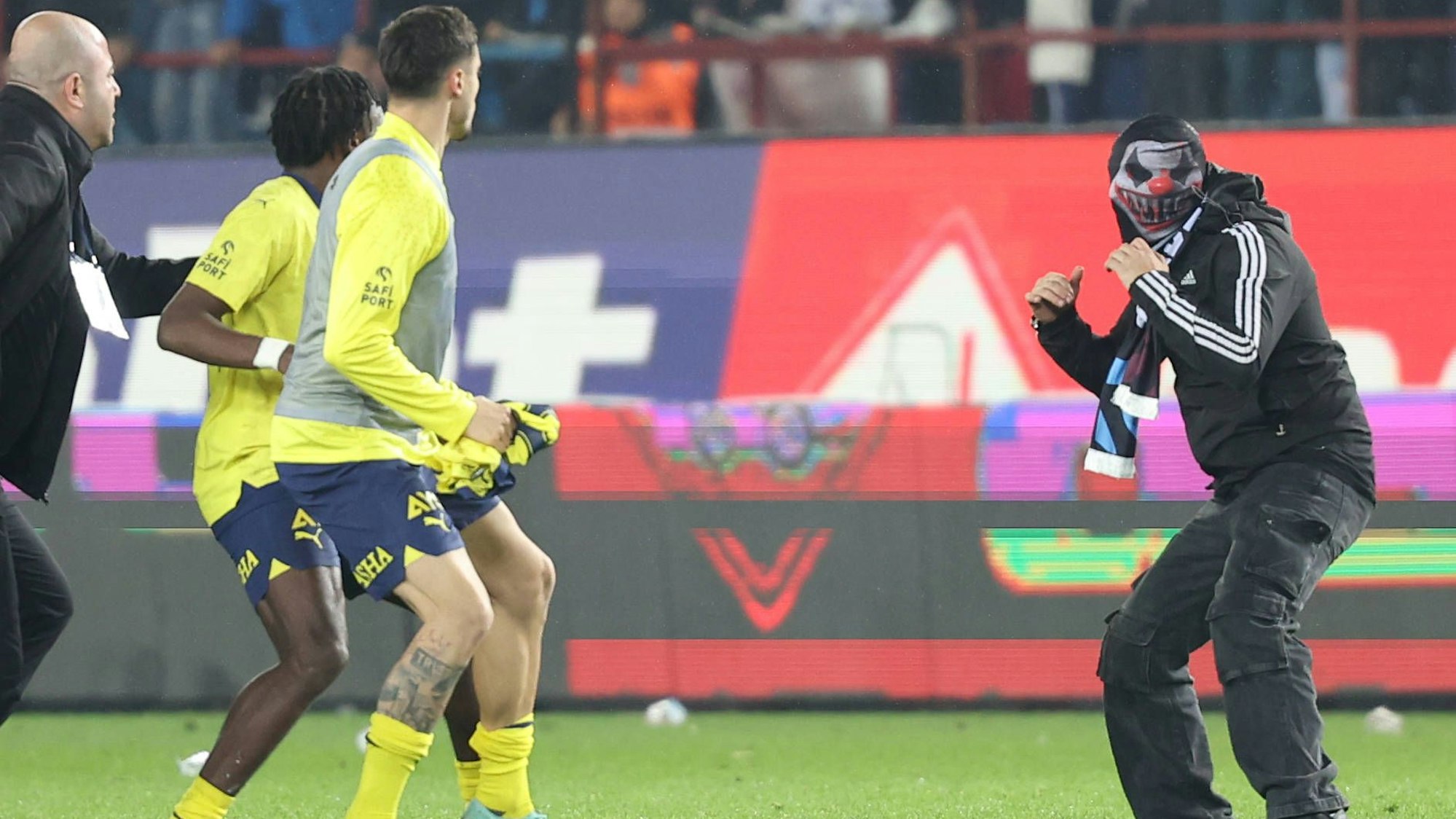 Ein Trabzonspor-Anhänger steht Spielern von Fenerbace Istanbul mit gehobenen Fäusten gegenüber.