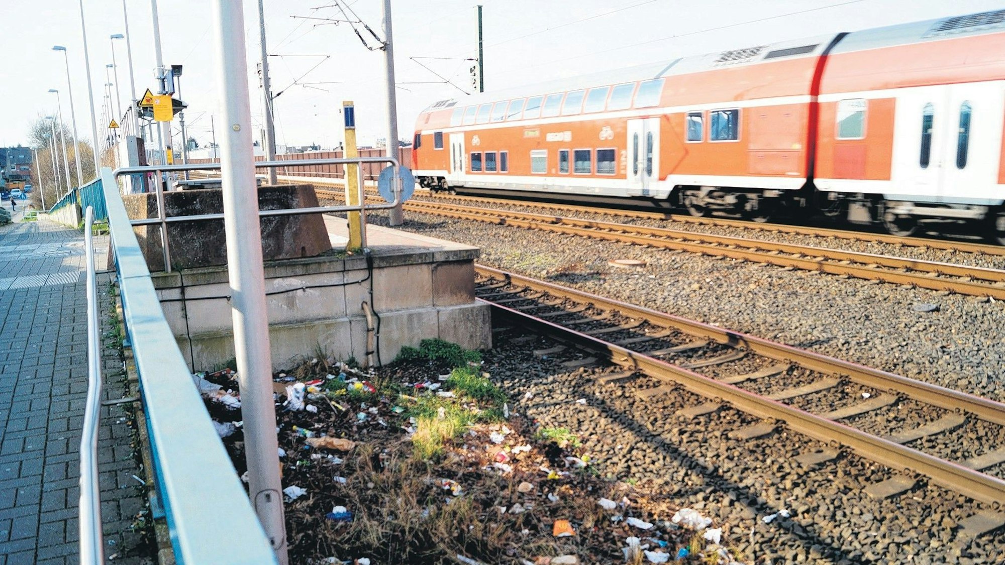 Eine Regionalbahn durchquert den Bahnhof Sindorf. Verschmutzung im Gleisbett ist zu sehen.