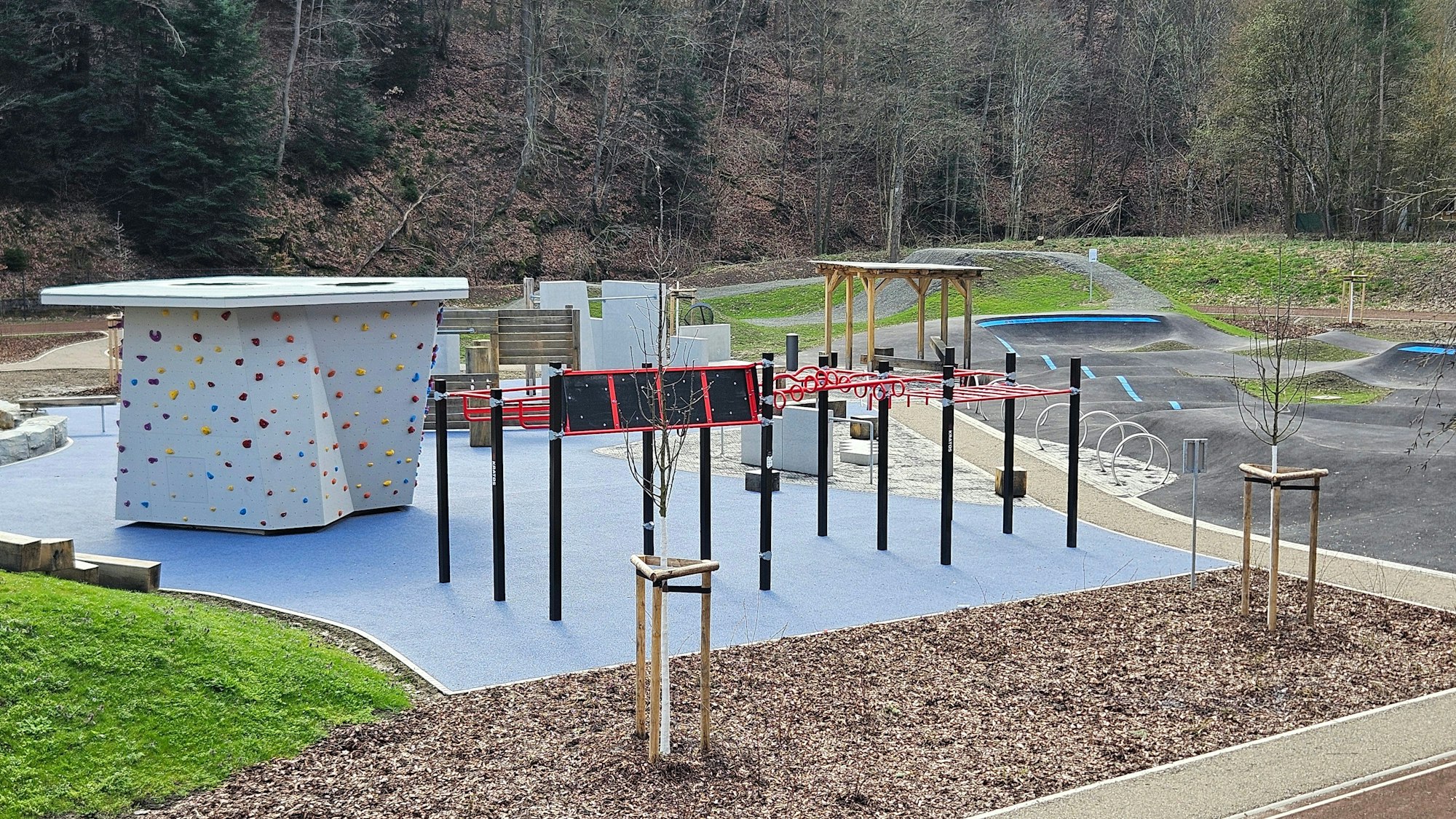 Das Foto zeigt eine Kletterwand und ähnliche Angebote und zwei Mountaimbikeparcours.