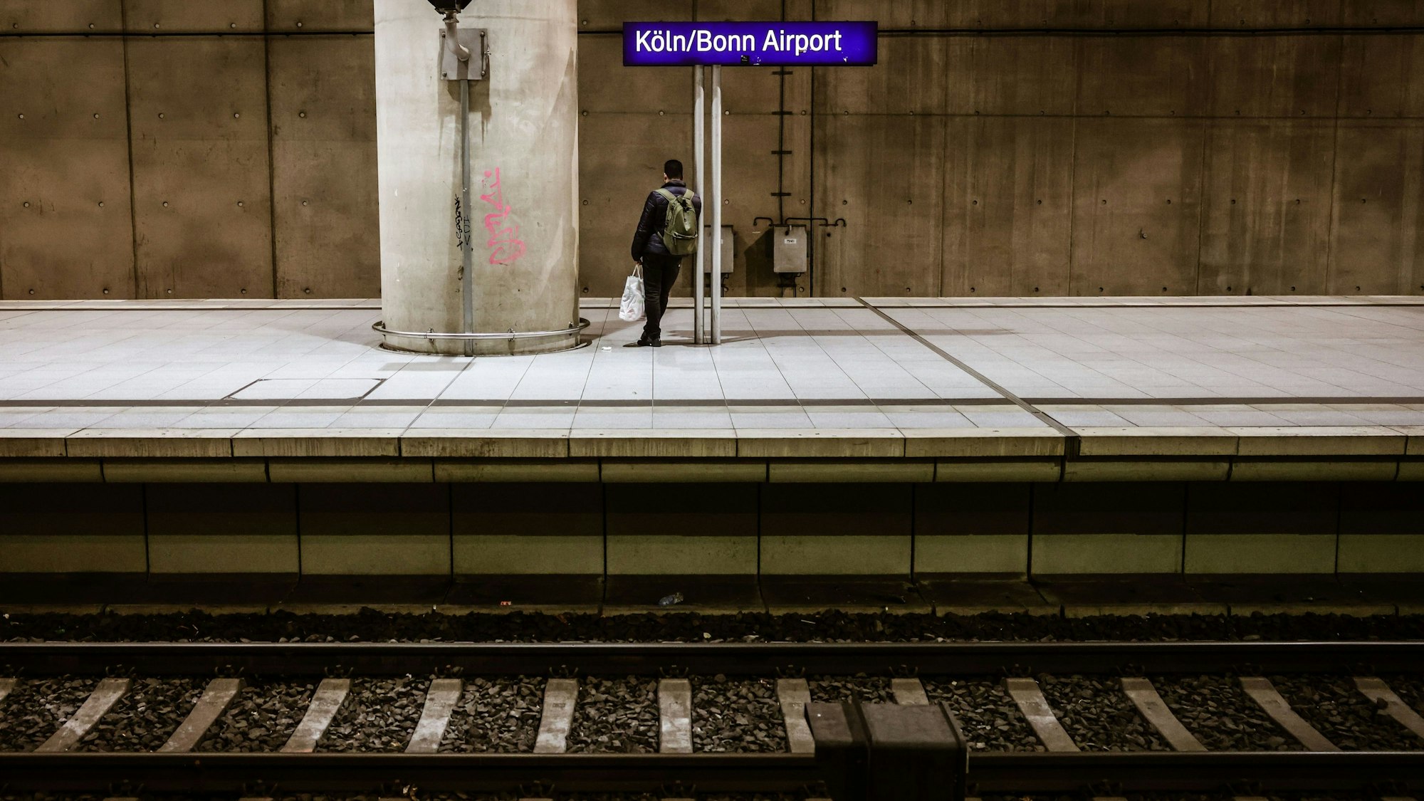 Ein Mann steht am Kölner Flughafenbahnhof auf dem Bahnsteig. Die Gewerkschaft Deutscher Lokomotivführer (GDL) verzichtet vorerst auf Streiks bei der Deutschen Bahn – eine Einigung im Tarifstreit gibt es aber noch nicht.