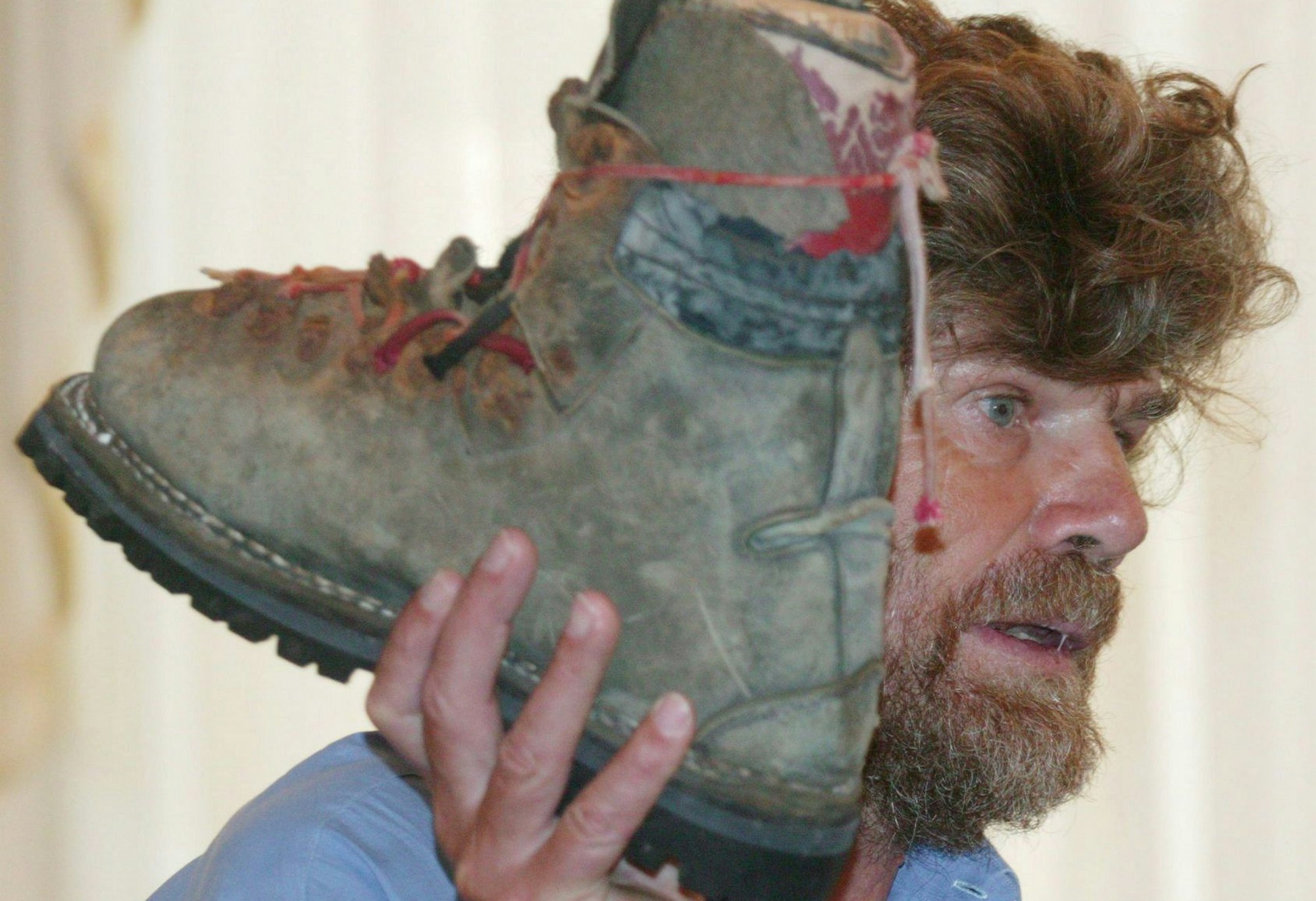 Bergsteiger Reinhold Messner hält einen Schuh, der seinem Bruder gehört haben soll.