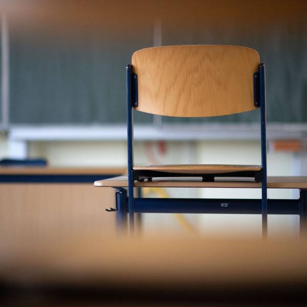 Ein Stuhl steht in einem Klassenzimmer einer Regelschule auf einem Tisch.