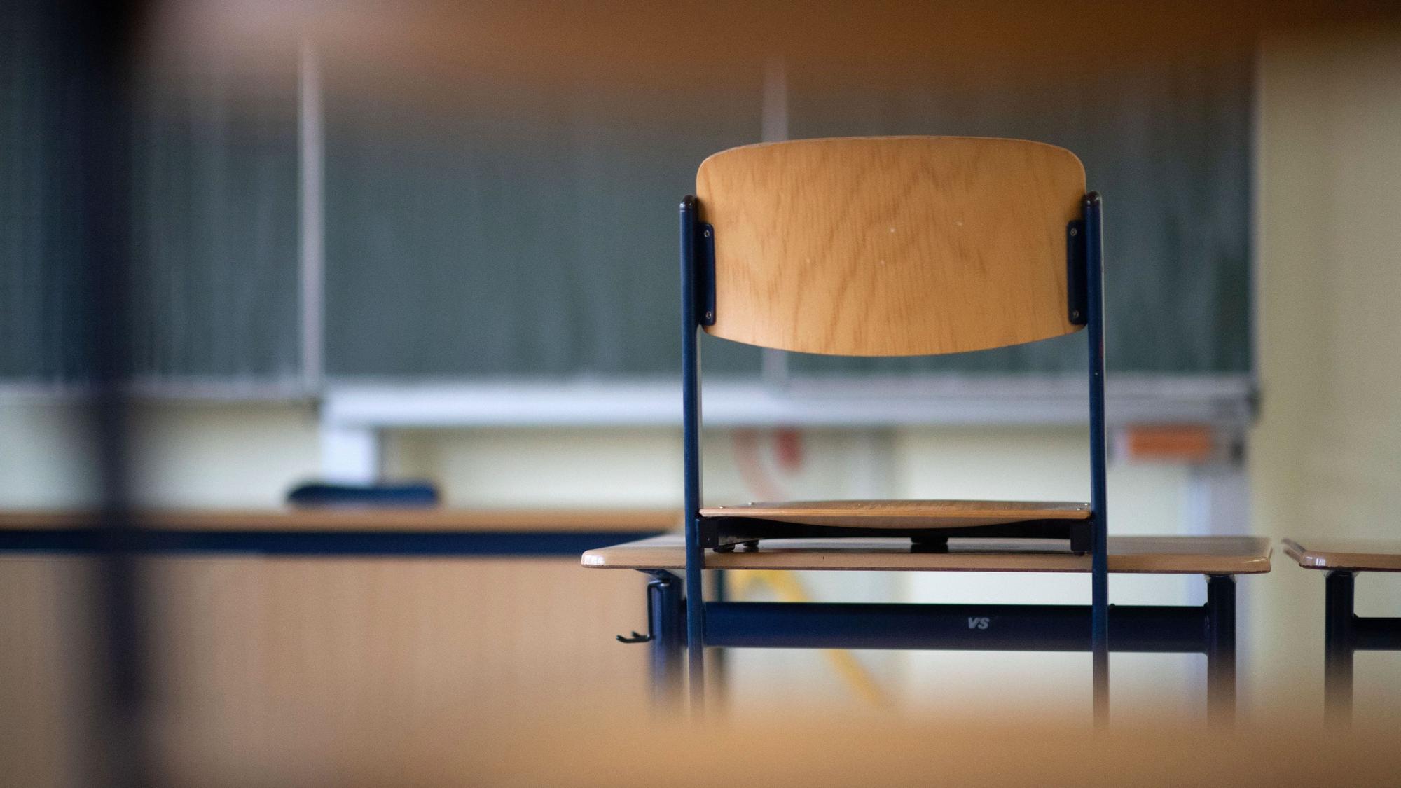 Ein Stuhl steht in einem Klassenzimmer einer Regelschule auf einem Tisch.