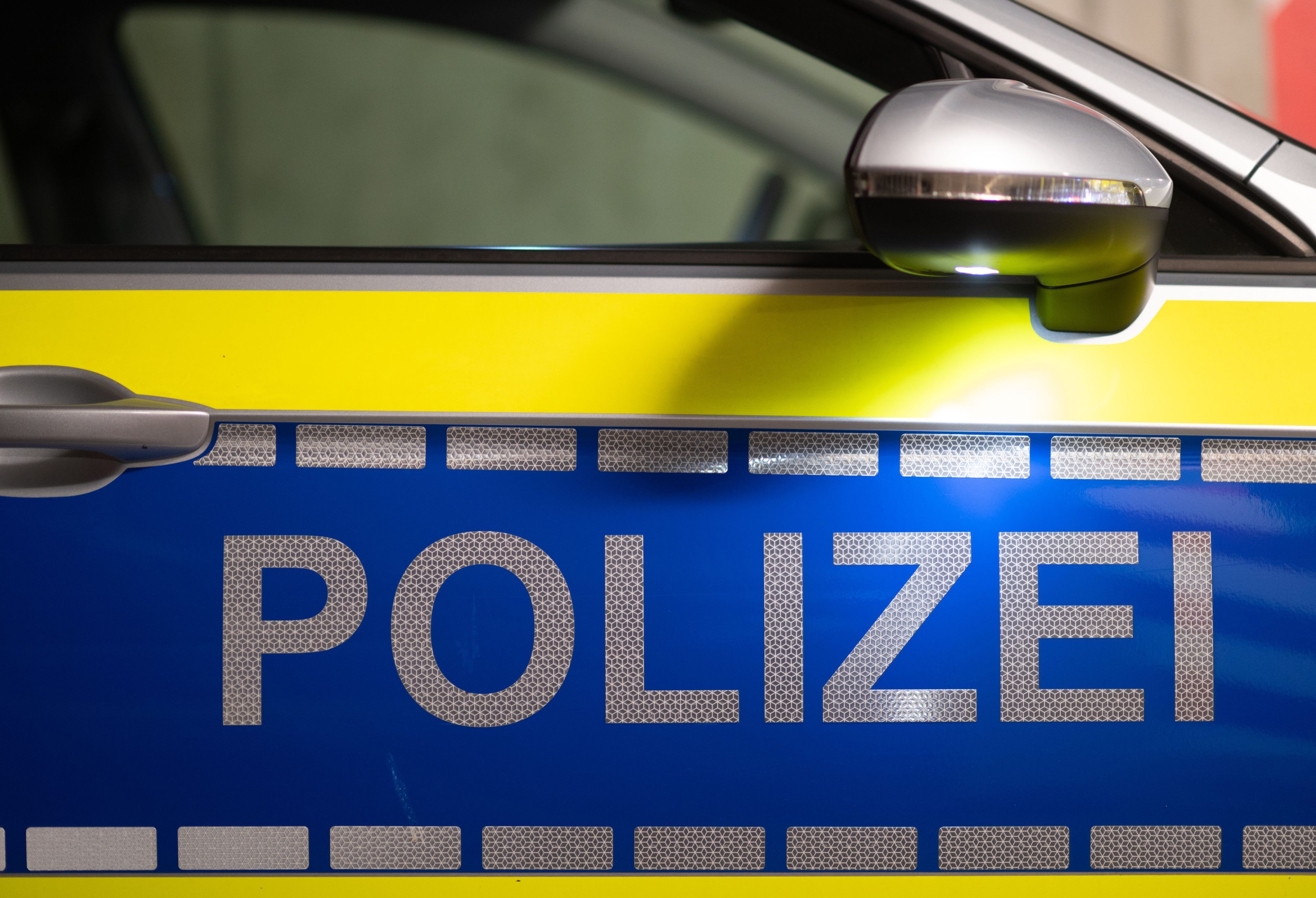 „Polizei“ ist auf der Tür eines Polizeiautos zu lesen.