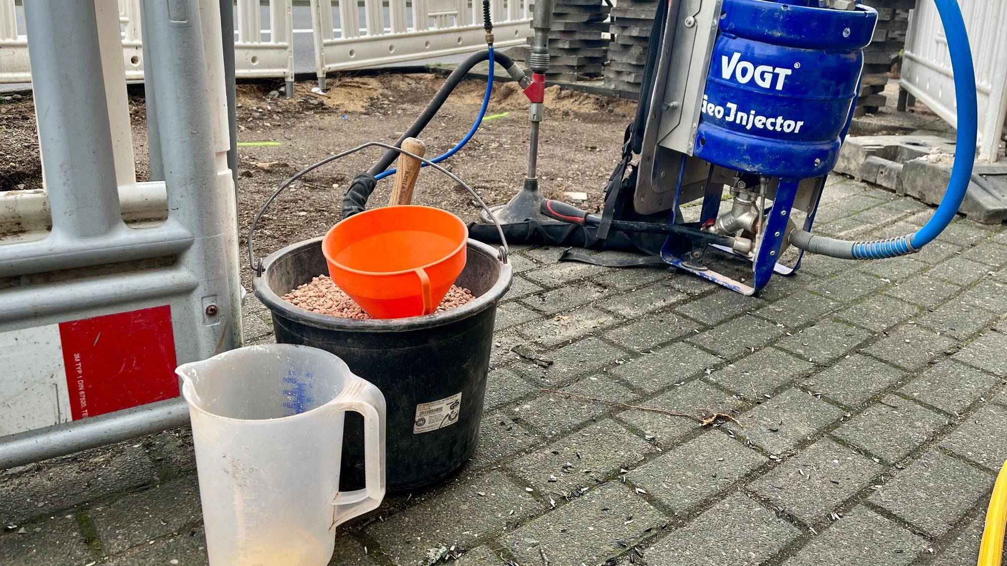 Im Eimer vorne ist das Substrat, das mit der blauen Maschine in die Erde gepumpt wird.