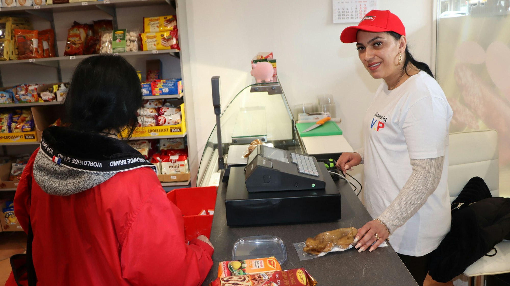 Zu sehen ist die Ladenbesitzerin an der Kasse des Geschäfts.