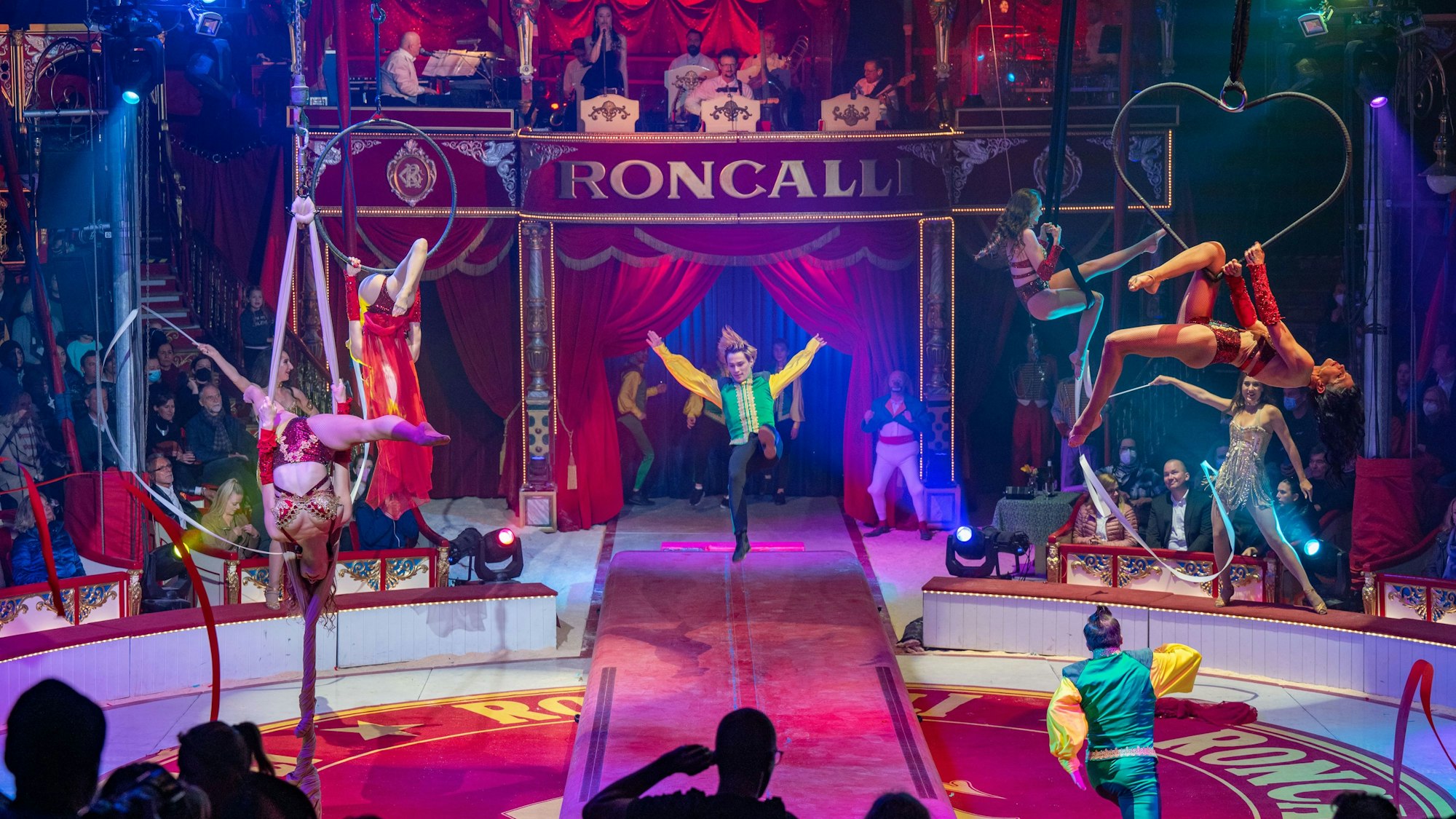 Mehrere Artisten sind in der Manege aktiv.