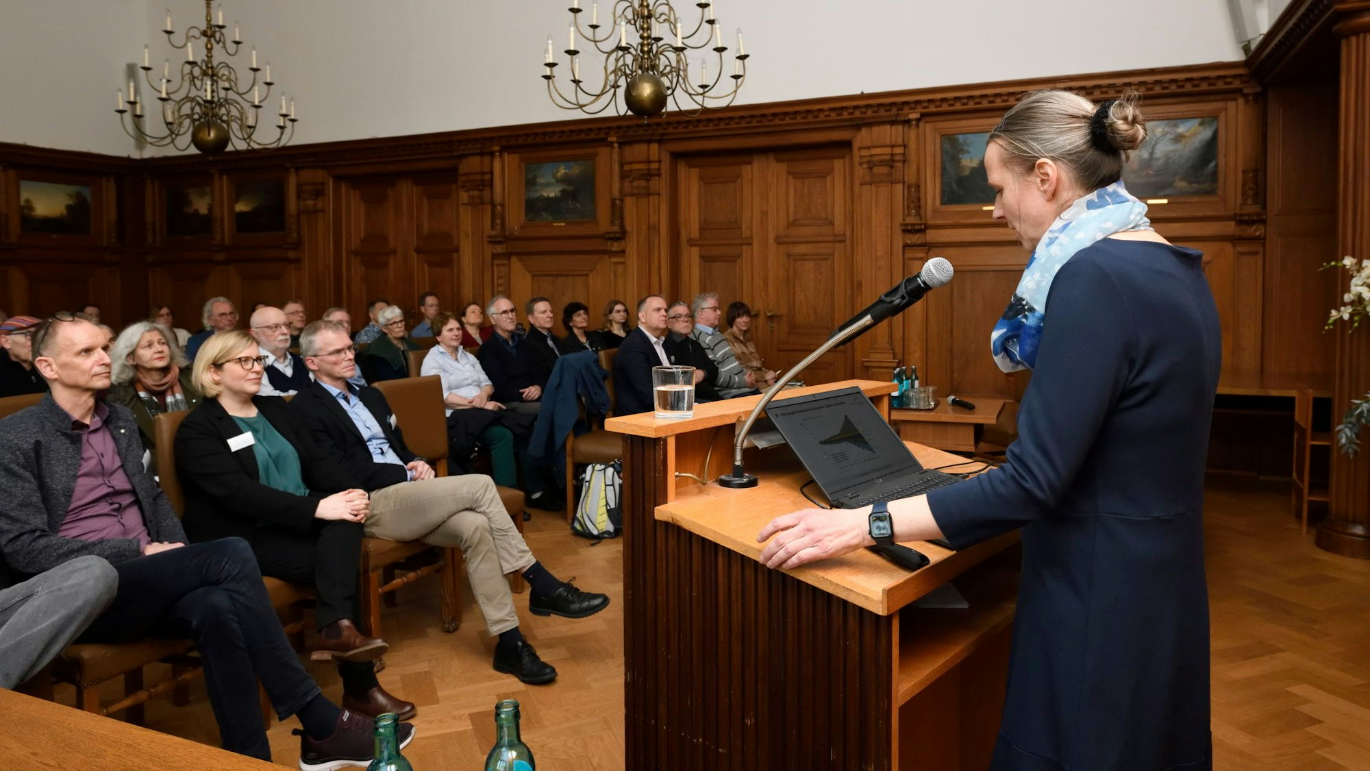 Rednerin Diana Rechid steht am Rednerpult im Ratsaal des Rathauses Bergisch Gladbach. Sie spricht  zum Integrierten Klimaschutzkonzept.