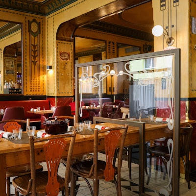 Das „Le Moissonnier Bistro'“ von innen, mit Holztischen und roten Bänken.