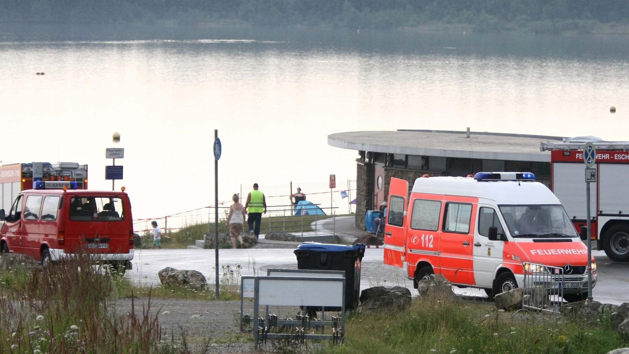 Polizei und Rettungsfahrzeuge am Blausteinsee im nordrhein-westfälischen Eschweiler. Kurz zuvor war eine Leiche aus dem Badesee gezogen worden. (Archivbild)
