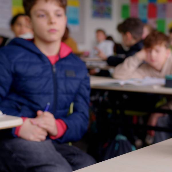 Ein kleiner weißer Roboter in einer Klasse
