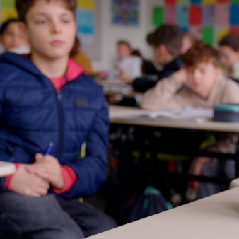 Ein kleiner weißer Roboter in einer Klasse