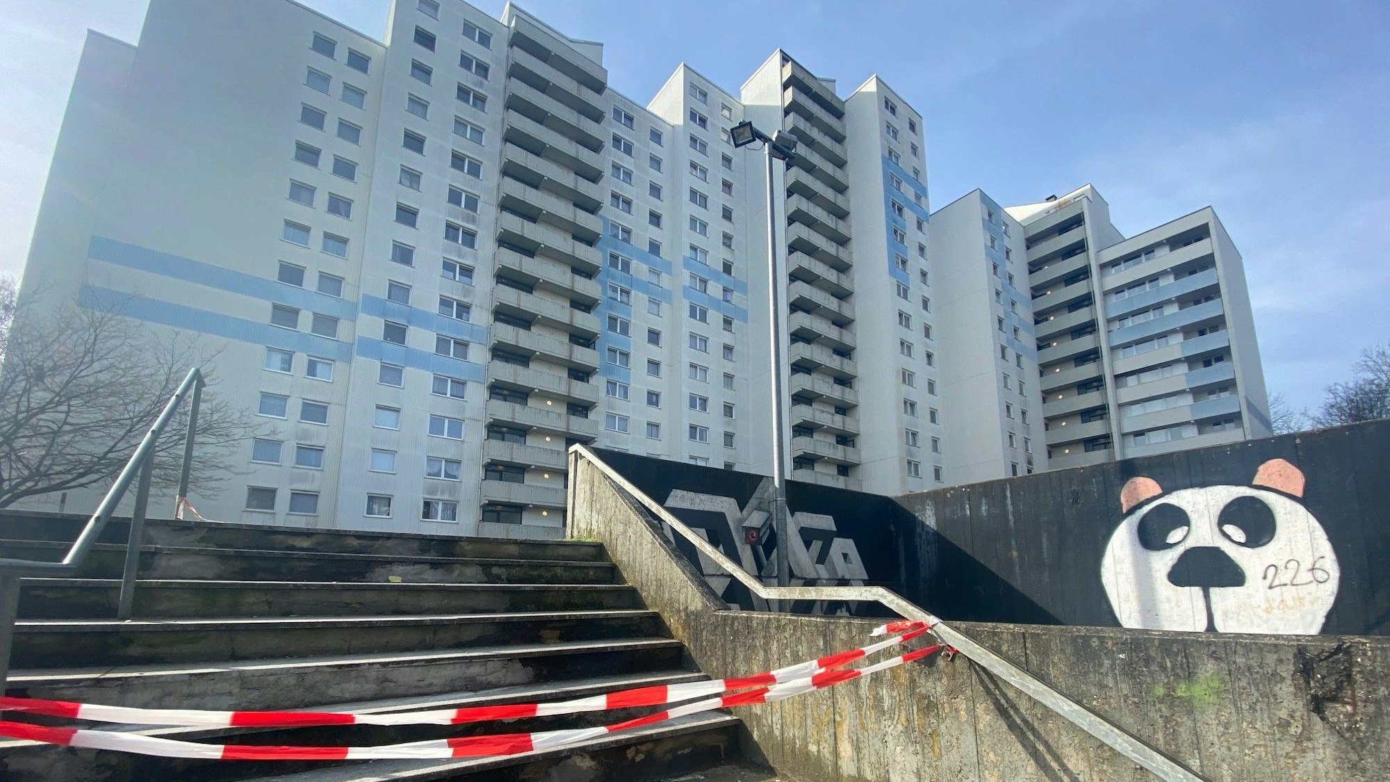 Auf dem Bild ist eine abgesperrte Treppe vor einer Wohnanlage zu sehen.
