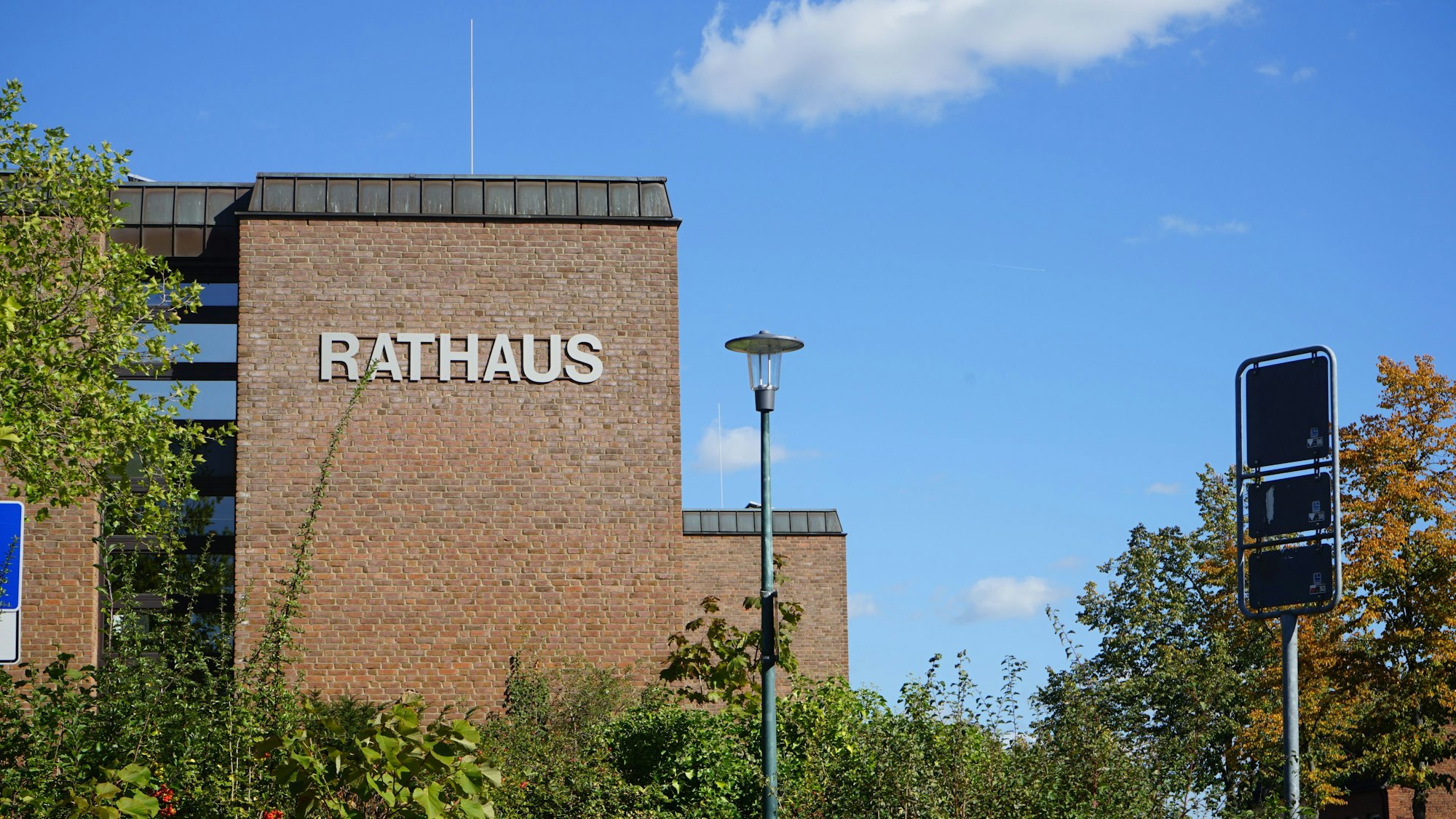 Zu sehen ist das Gebäude des Rathauses, das Gebäude besteht aus rötlichen Backsteinen.