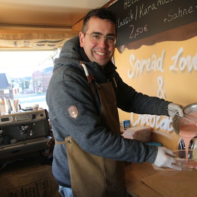Der Chocolatier gießt flüssige Schokolade in eine Schüssel.