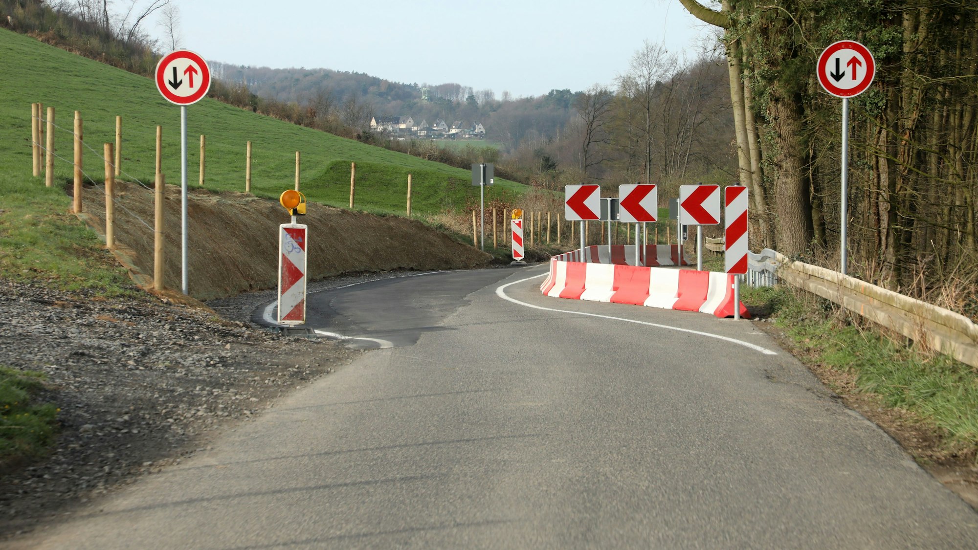 Barken und Markierungen verschwenken die Straße K 38 im Holzbachtal bei Overath-Steinenbrück.