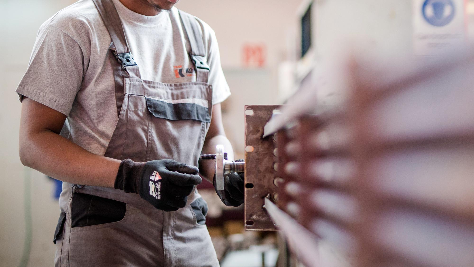 Ein Flüchtling aus Somalia arbeitet während eines Praktikums bei einem Industrieunternehmen in der Produktion der Firma an einem Wärmetauscher.