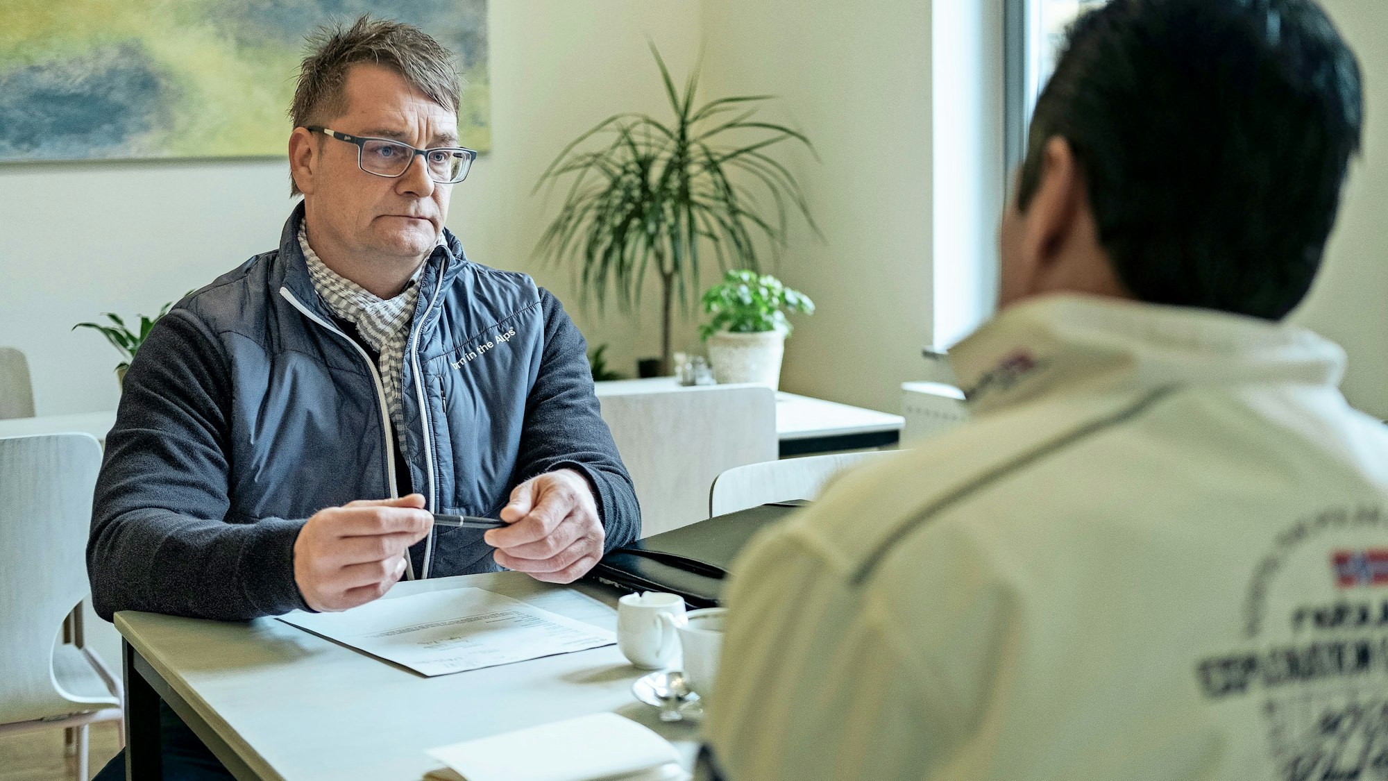 Kassel:
Sascha Riepel vom Jobcenter Kassel spricht mit einem Kunden in einer neutralen Umgebung.