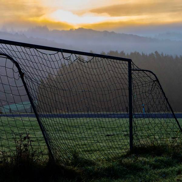 Das Bild zeigt den Bolzplatz zwischen Kolvenbach und Bouderath. Im Hintergrund geht die Sonne auf.