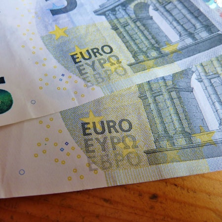 Zwei 5-Euro-Scheine liegen auf einem Tisch. Symbolbild