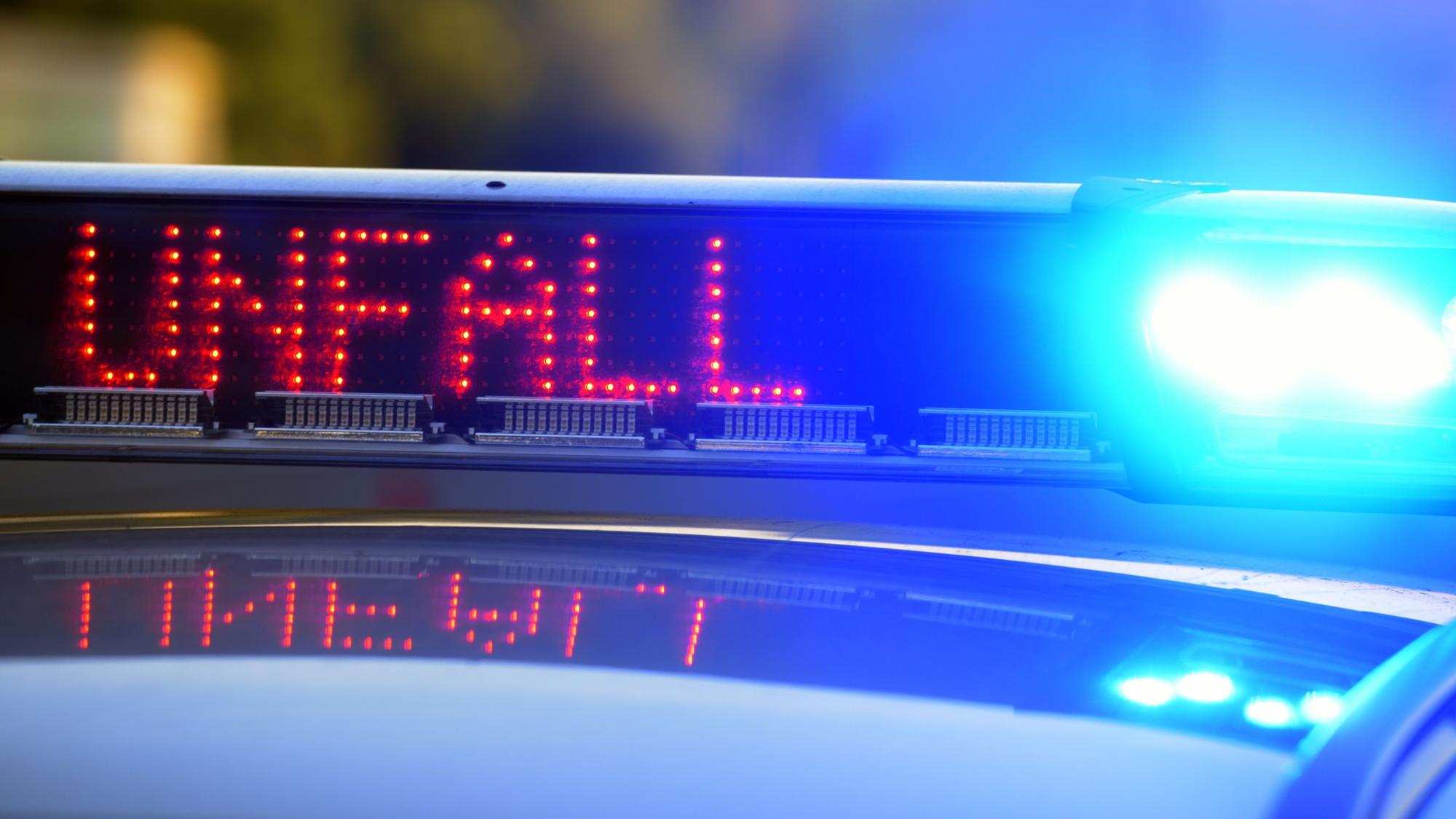 Auf einem Polizeifahrzeug warnt eine Leuchtschrift vor einer Unfallstelle.