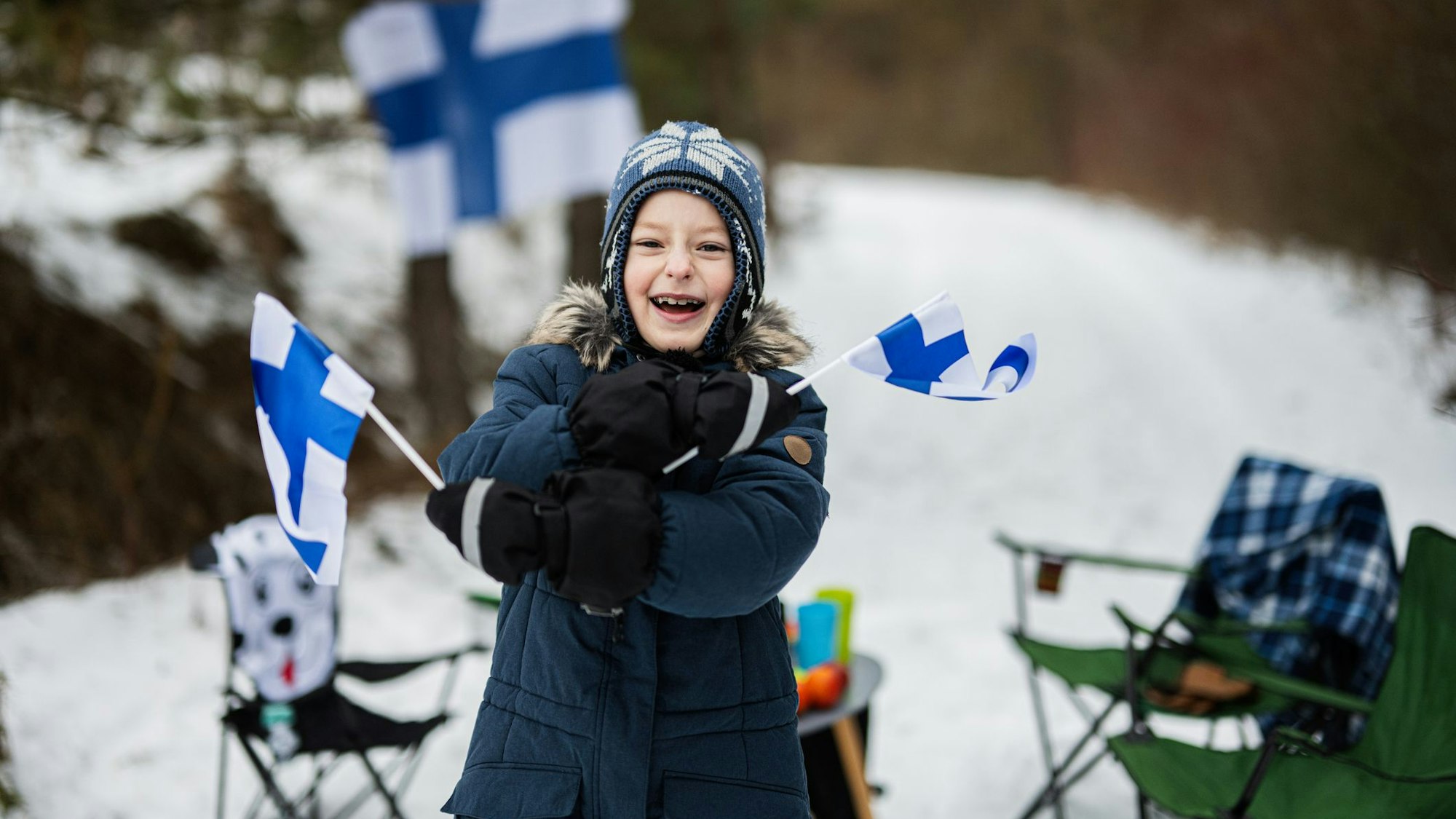 Finnish boy with Finland flags on a nice winter day. Nordic Scandinavian people.