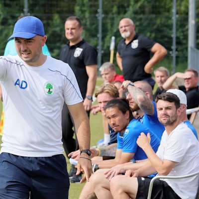 Das Bild zeigt Trainer Albert Deuker, der mit der Hand in Richtung Fußballtor zeigt.