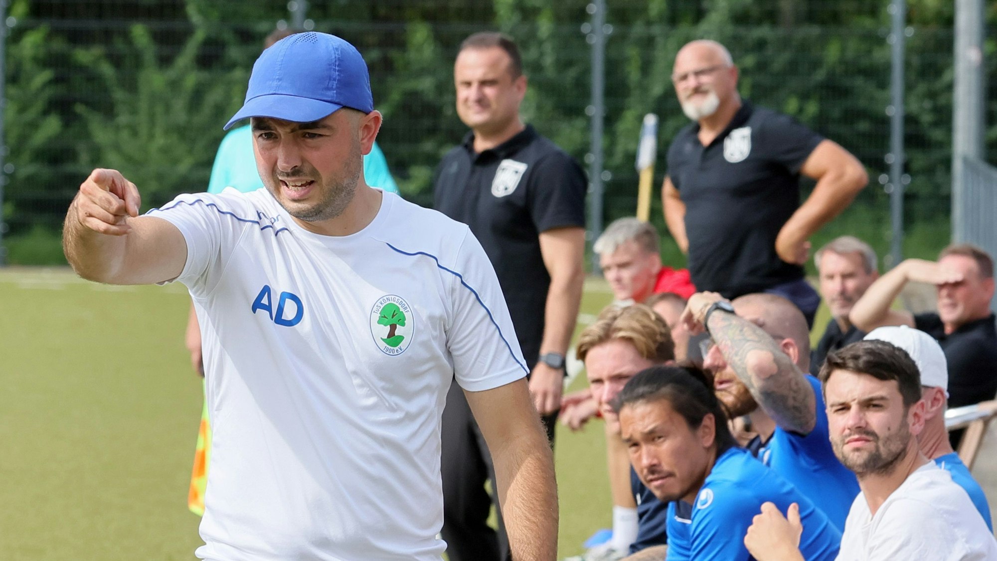 Das Bild zeigt Trainer Albert Deuker, der mit der Hand in Richtung Fußballtor zeigt.