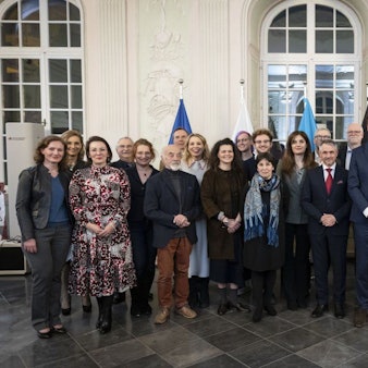 28 Frauen und Männer lächeln in die Kamera, Ministerpräsident Hendrik Wüst überragt sie alle.