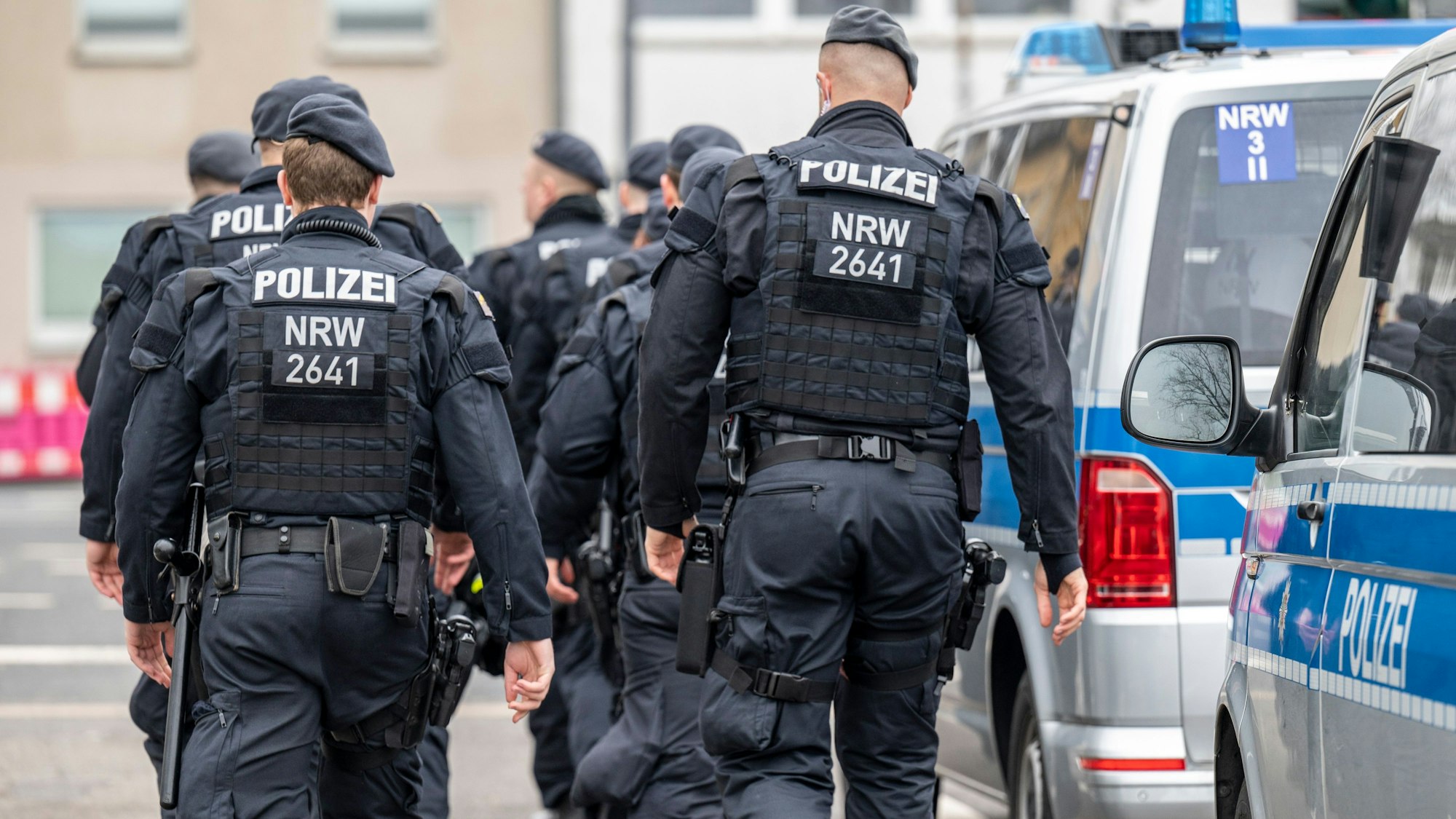 Eine Gruppe an Polizisten läuft auf der Straße.