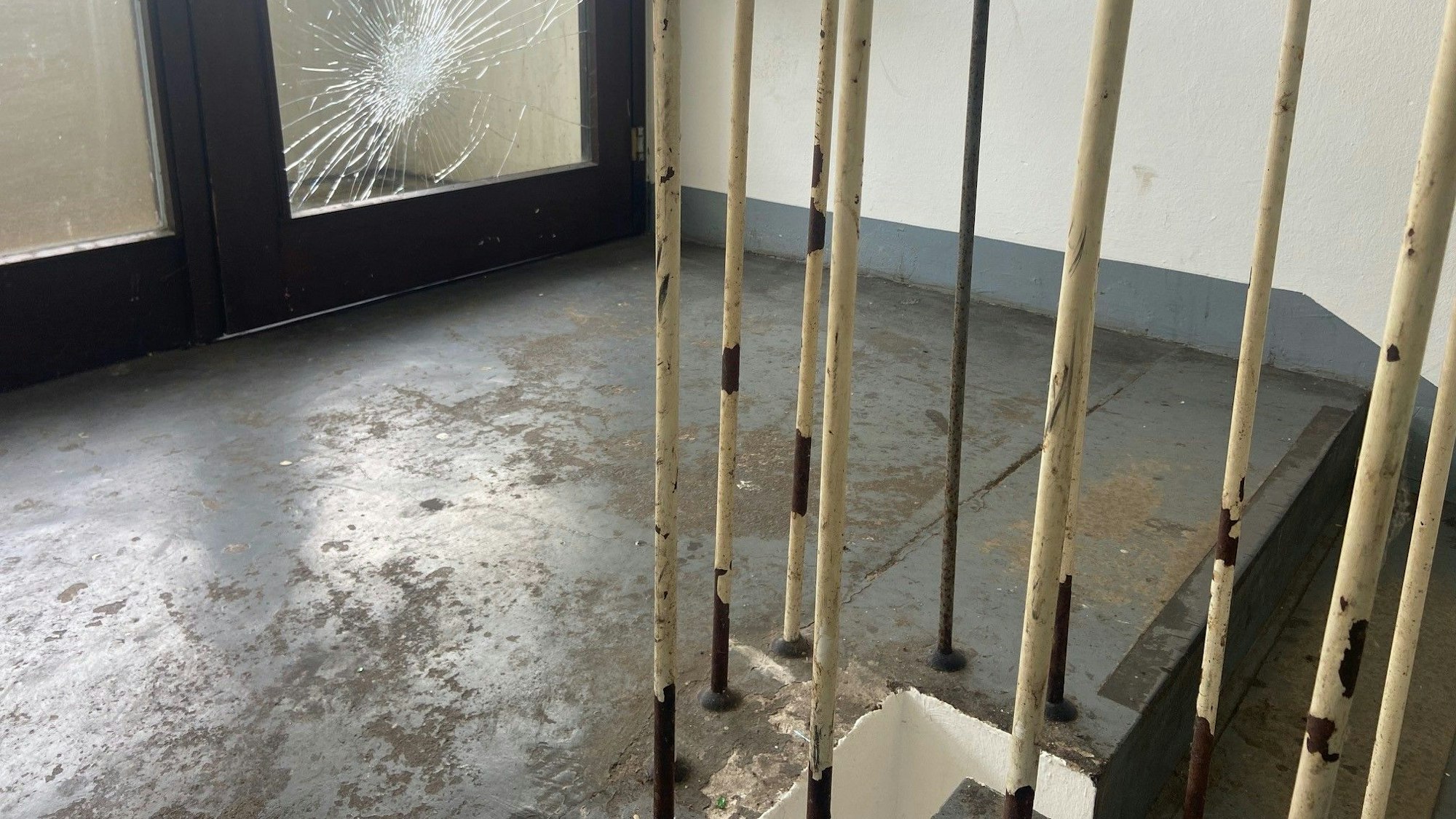 Auf dem Bild ist ein kaputtes Fenster im Treppenhaus zu sehen.