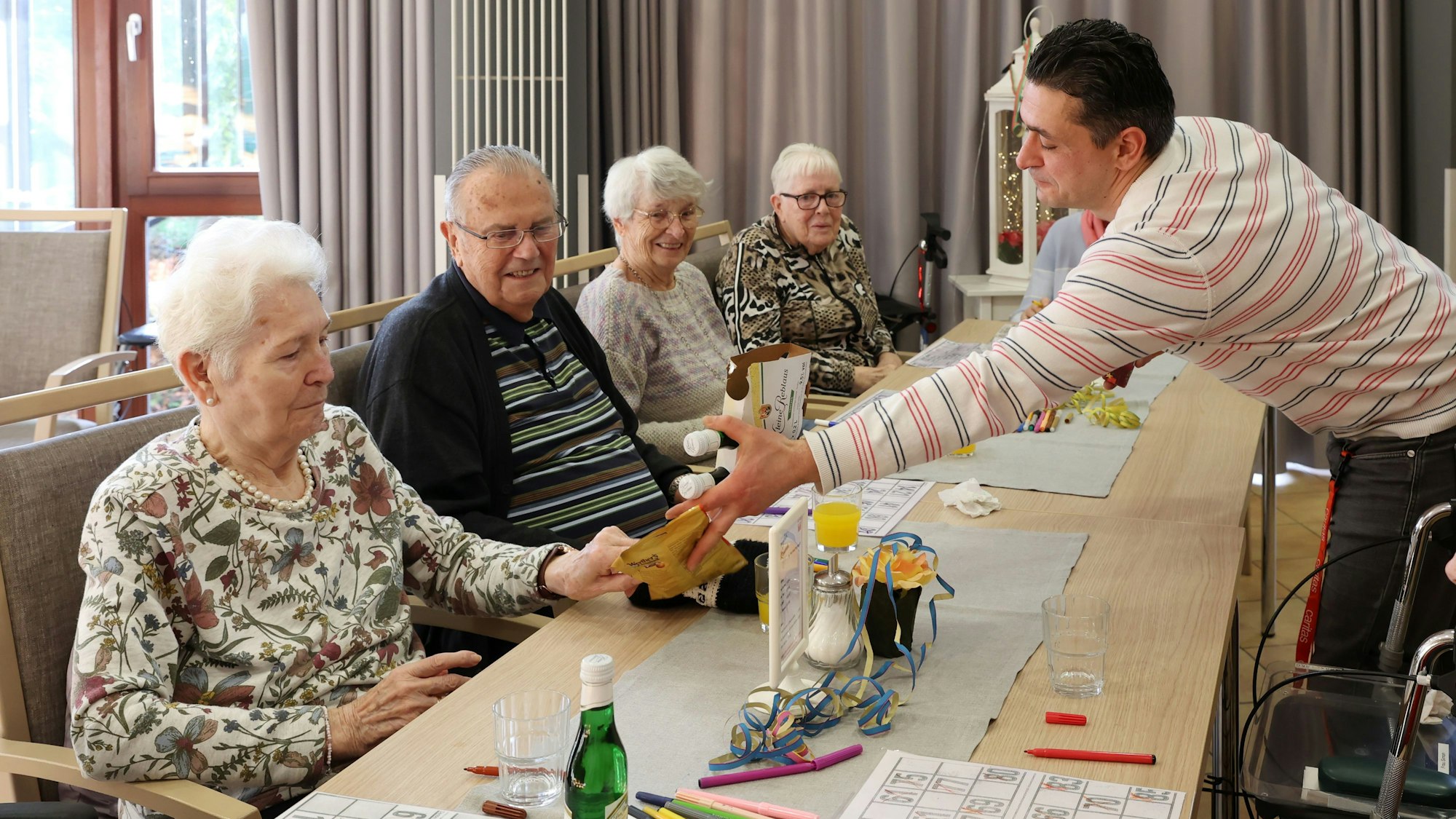 Ali Emili war früher Hartz-IV-Empfänger und erzählt uns jetzt, warum es sich für ihn lohnt, lieber arbeiten zu gehen.
Er leitet u.a. das BINGO Spiel im Caritas-Seniorenzentrum Sebastianusstift