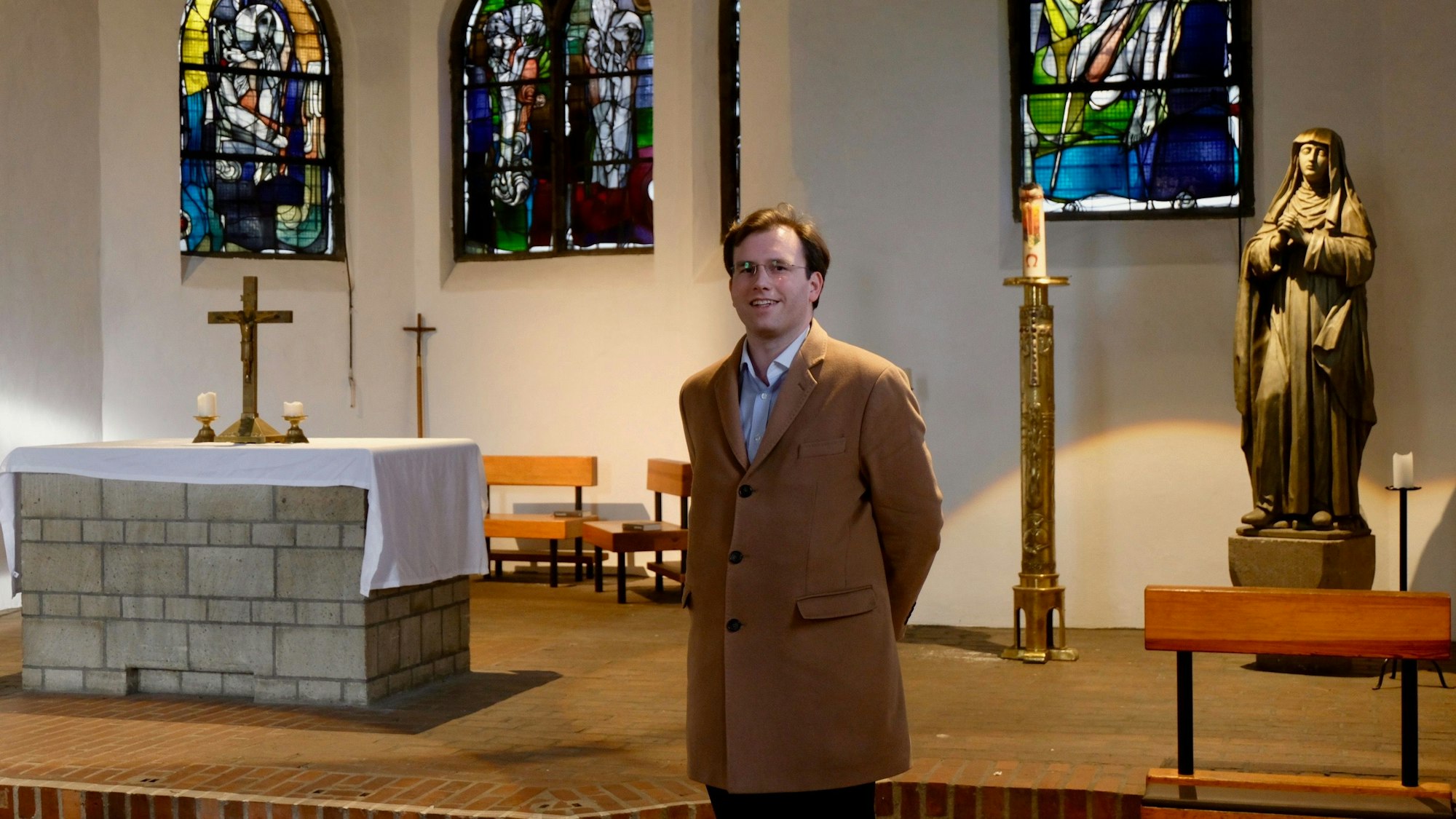 Ein Mann steht in einem Kirchenraum.